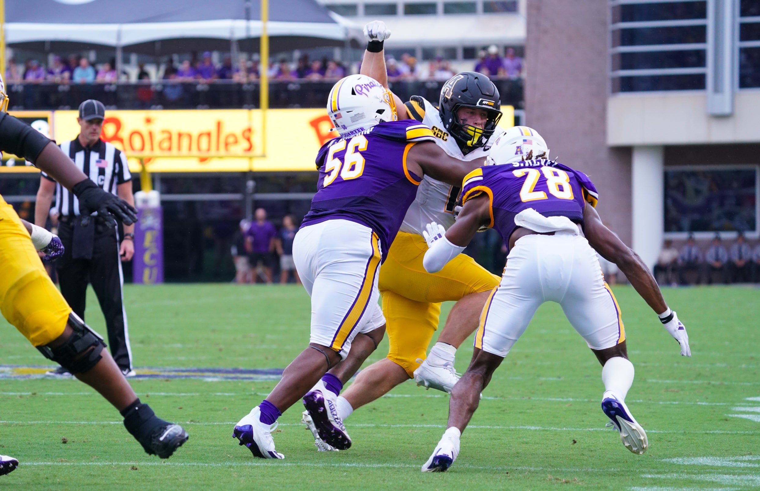 Sep 14, 2024; Greenville, North Carolina, USA; East Carolina Pirates defensive lineman D'Anta Johnson (56) and defensive back Shavon Revel Jr. (28) stops the run by Appalachian State Mountaineers running back Anderson Castle (1) during the first half at Dowdy-Ficklen Stadium.