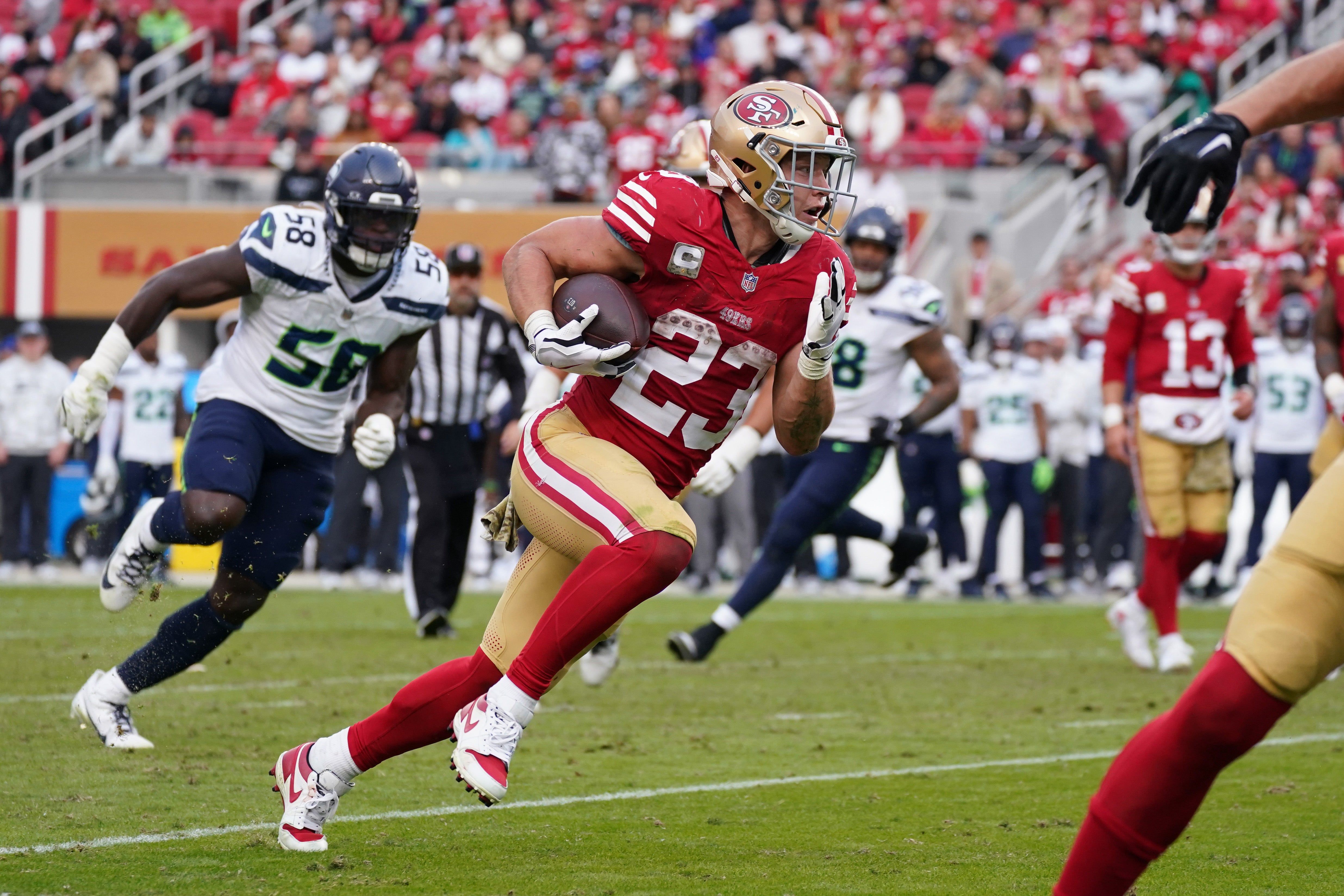 San Francisco 49ers running back Christian McCaffrey (23) rushes the ball while be pursued by Seattle Seahawks linebacker Derick Hall (58) in the fourth quarter at Levi's Stadium.