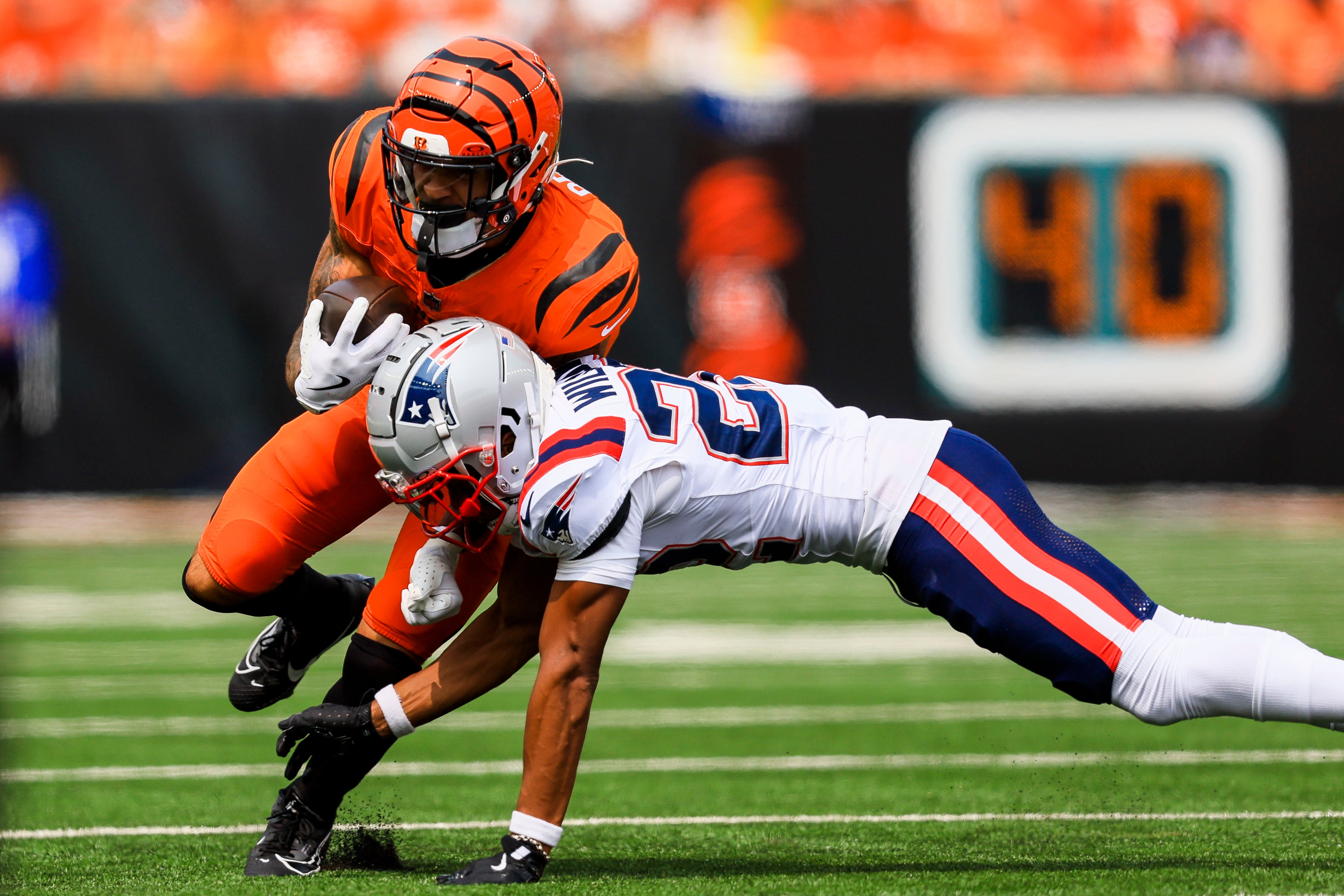 Sep 8, 2024; Cincinnati, Ohio, USA; Cincinnati Bengals running back Chase Brown (30) runs with the ball against New England Patriots cornerback Marco Wilson (22) in the first half at Paycor Stadium.