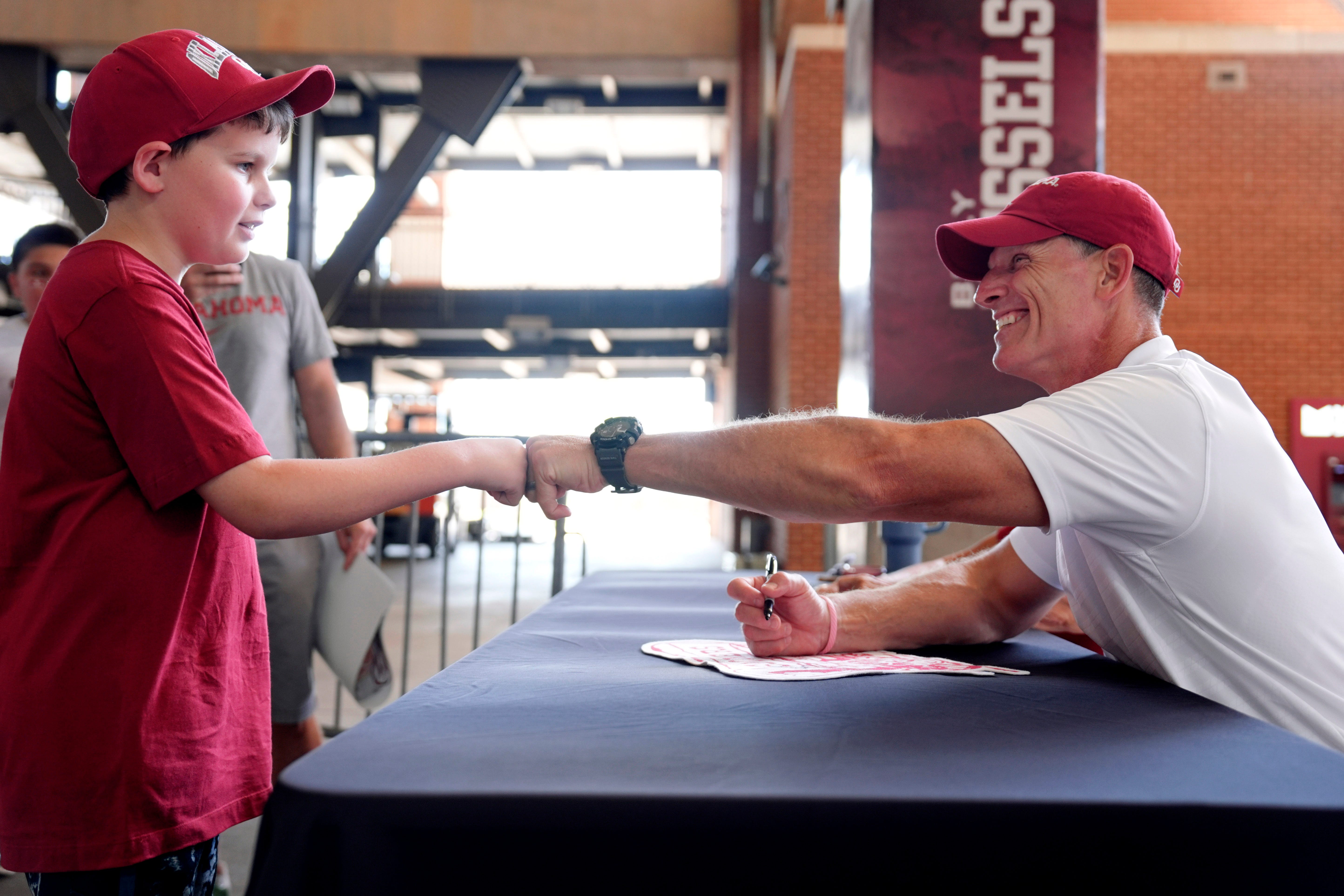 Kingsley Mullins, 10, bumps fists with OU coach Brent Venables during Meet the Sooners Day for the University of Oklahoma football team at Gaylord Family-Oklahoma Memorial stadium in Norman, Okla. Saturday, Aug. 3, 2024.