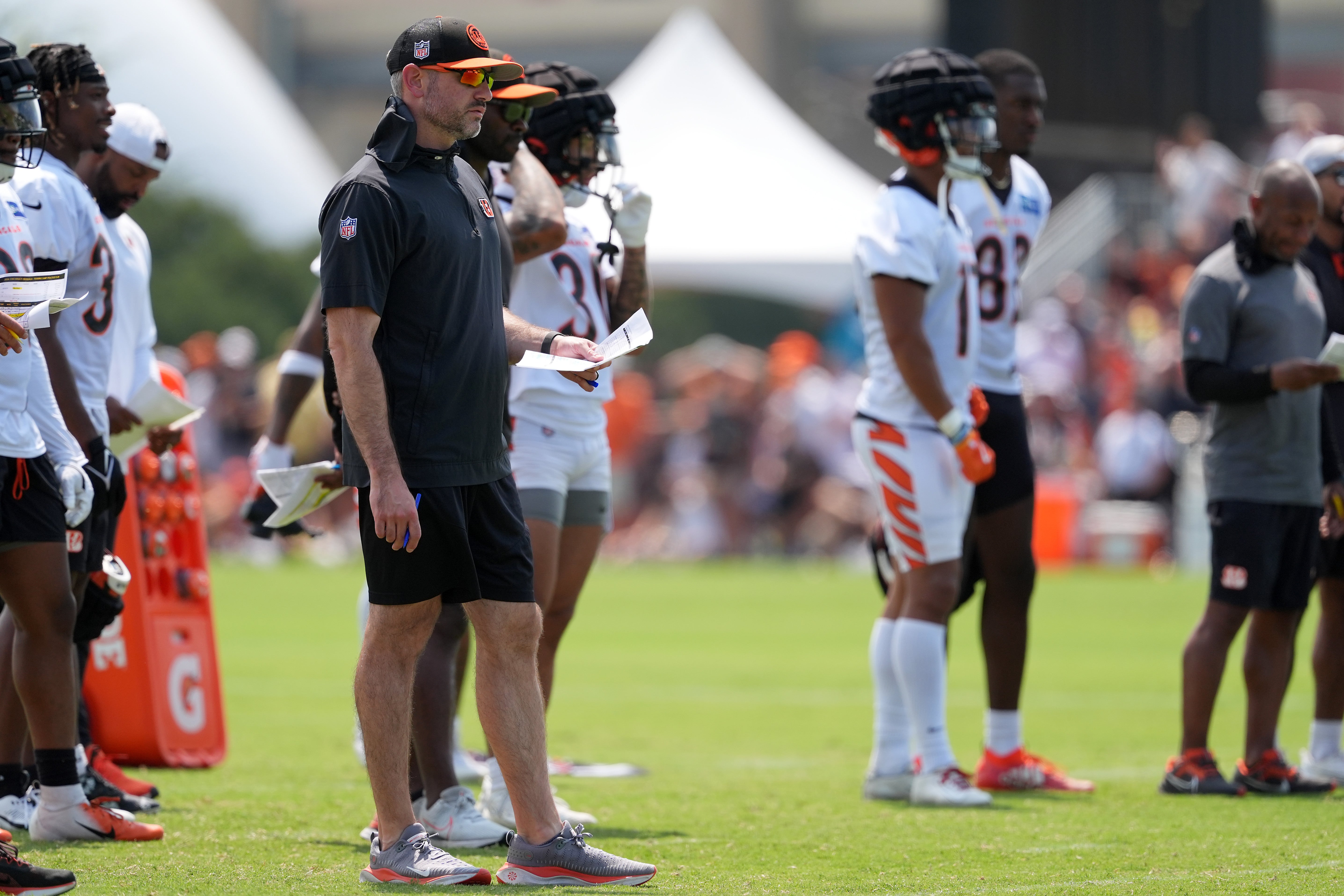 Jul 26, 2024; Cincinnati, OH, USA; Cincinnati Bengals offensive coordinator Dan Pitcher watches play during training camp practice at Kettering Health Practice Fields.