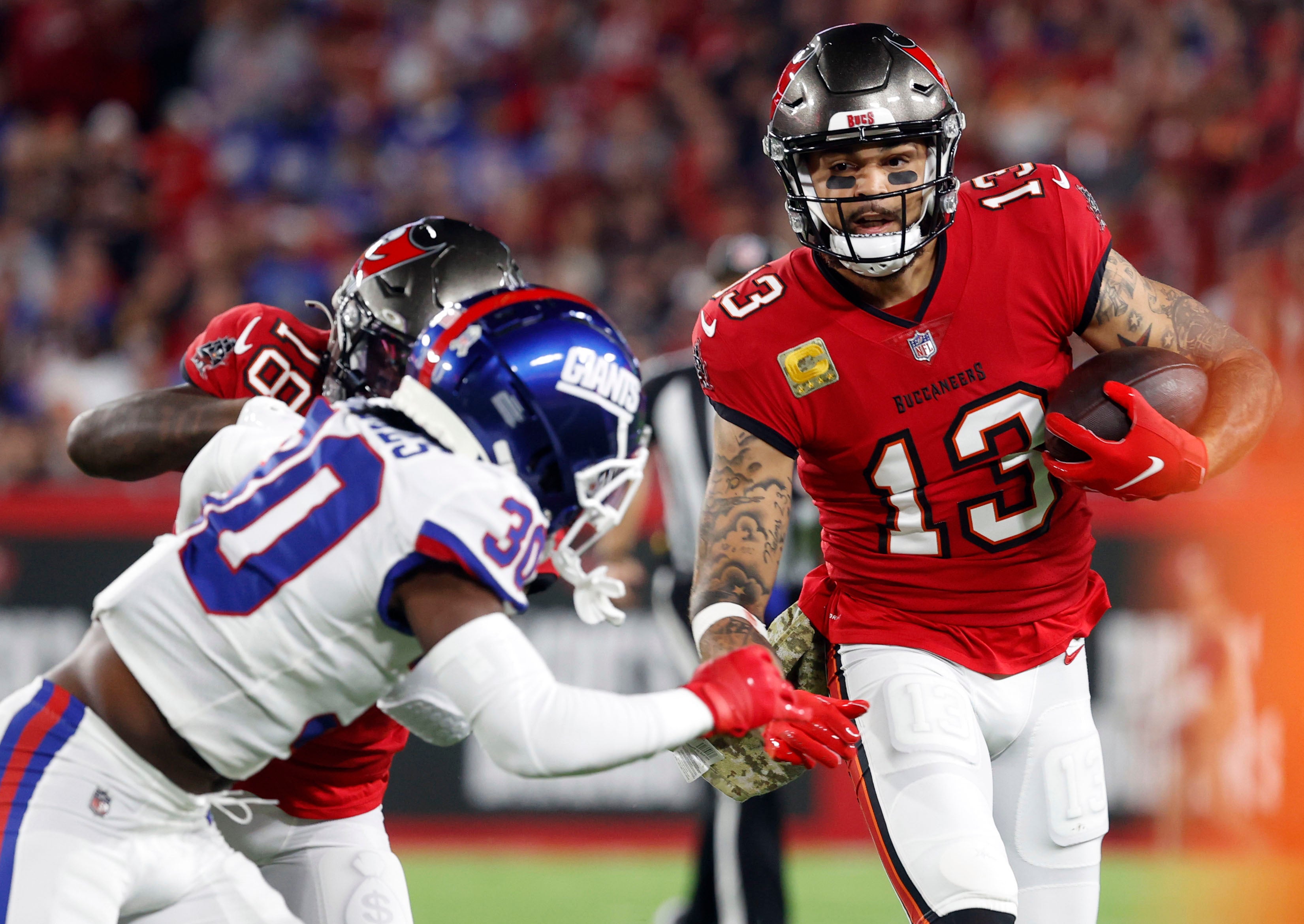 Nov 22, 2021; Tampa, Florida, USA; Tampa Bay Buccaneers wide receiver Mike Evans (13) runs with the ball as New York Giants cornerback Darnay Holmes (30) defends during the first quarter at Raymond James Stadium.