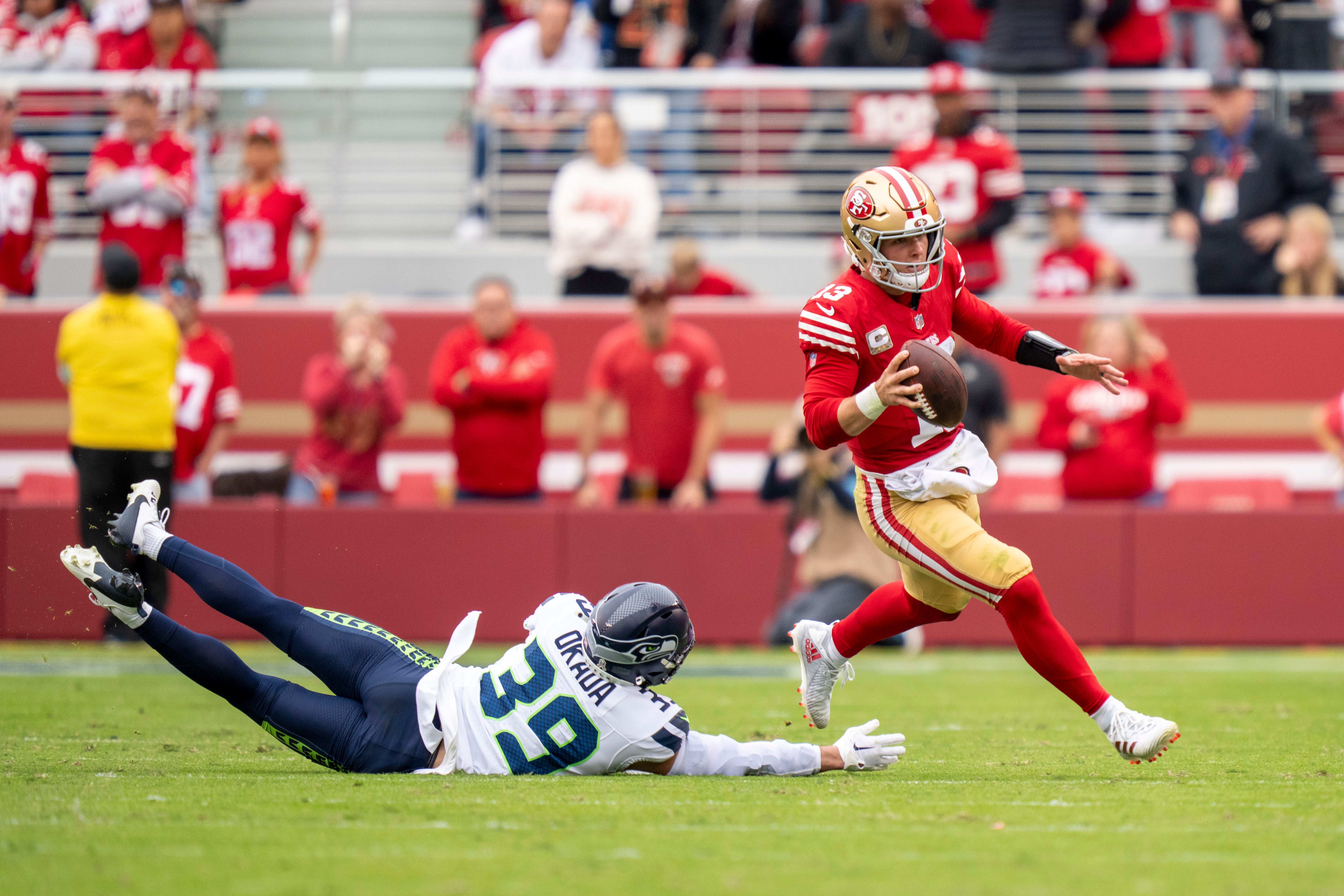 San Francisco 49ers quarterback Brock Purdy (13) runs past Seattle Seahawks safety Ty Okada (39) during the second quarter at Levi's Stadium