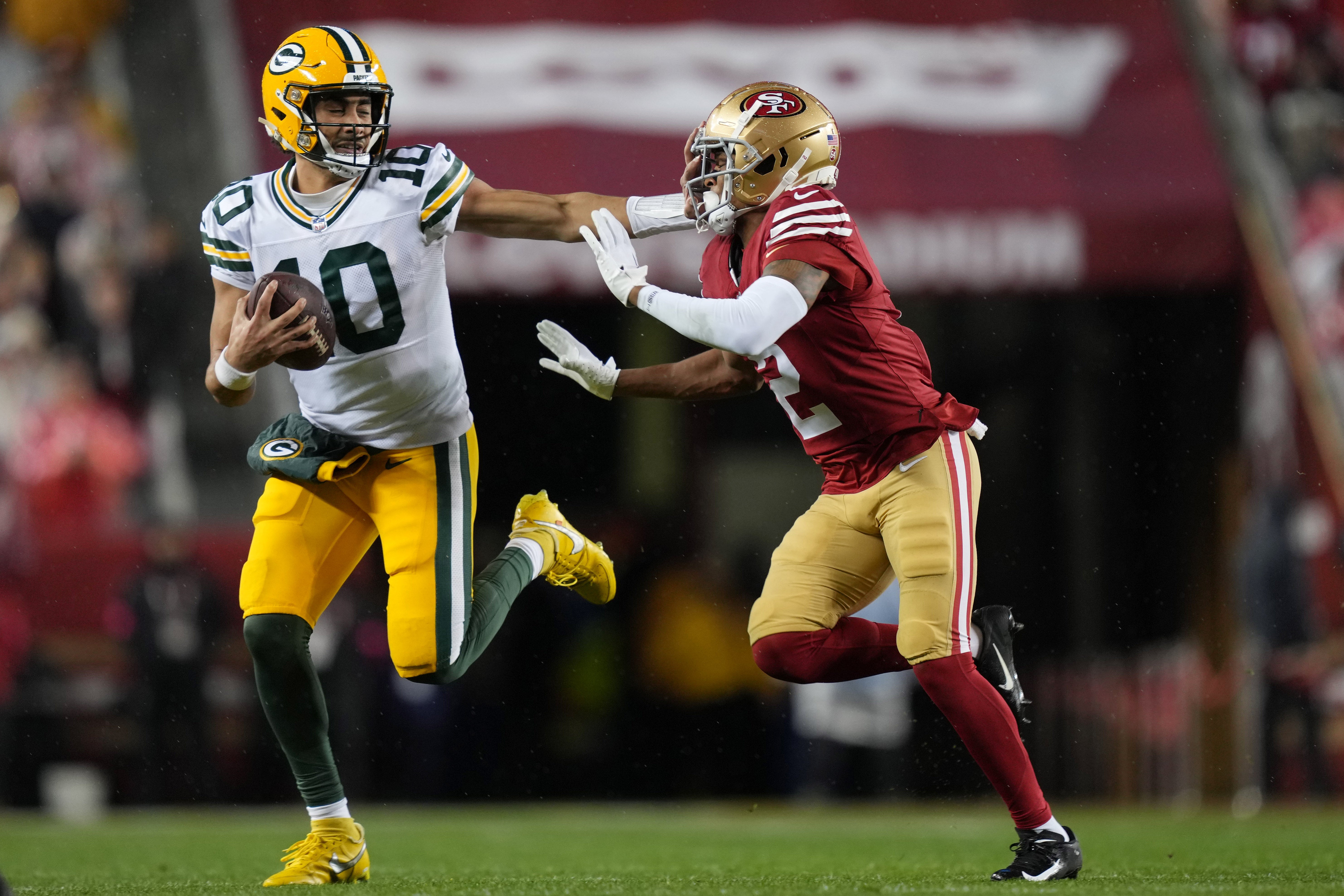 Green Bay Packers quarterback Jordan Love (10) runs against San Francisco 49ers cornerback Deommodore Lenoir (2) during the second quarter in a 2024 NFC divisional round game at Levi's Stadium.
