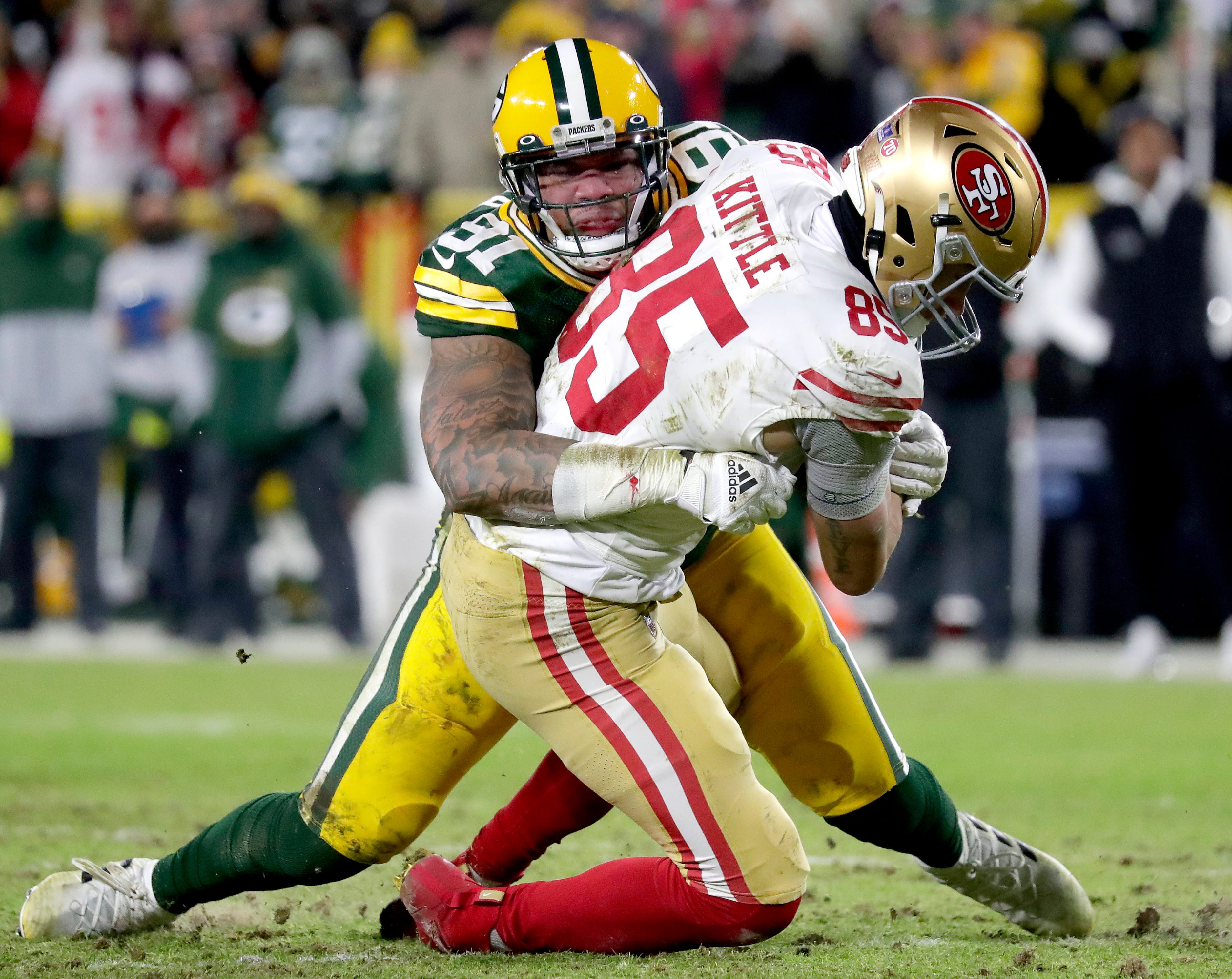 Green Bay Packers outside linebacker Preston Smith (91) tackles San Francisco 49ers tight end George Kittle (85) during their NFL divisional round playoff game on Saturday, January 22, 2022, at Lambeau Field in Green Bay, Wis.