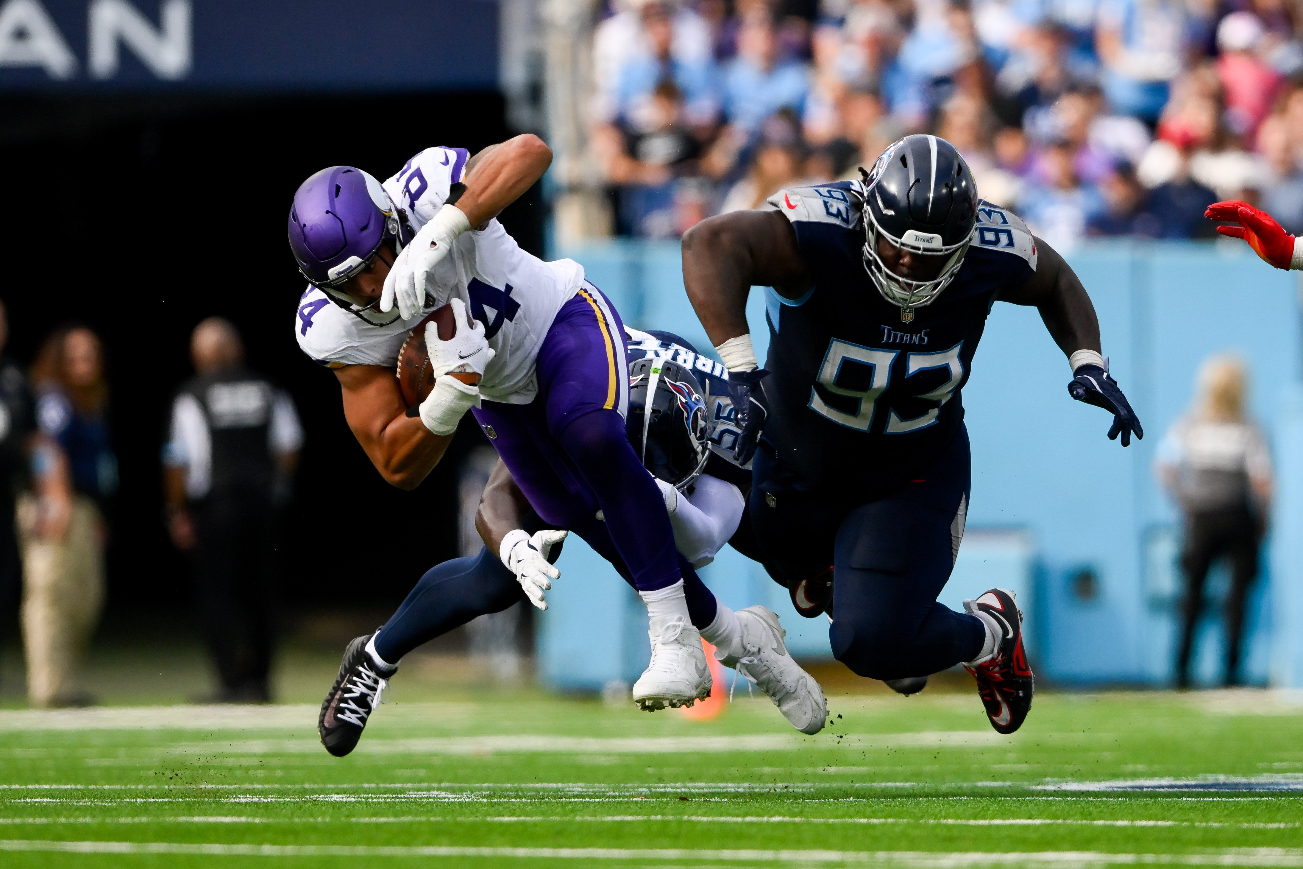 Nov 17, 2024; Nashville, Tennessee, USA; Tennessee Titans linebacker Kenneth Murray Jr. (56) and defensive tackle T'Vondre Sweat (93) tackle Minnesota Vikings tight end Josh Oliver (84) during the first half at Nissan Stadium.