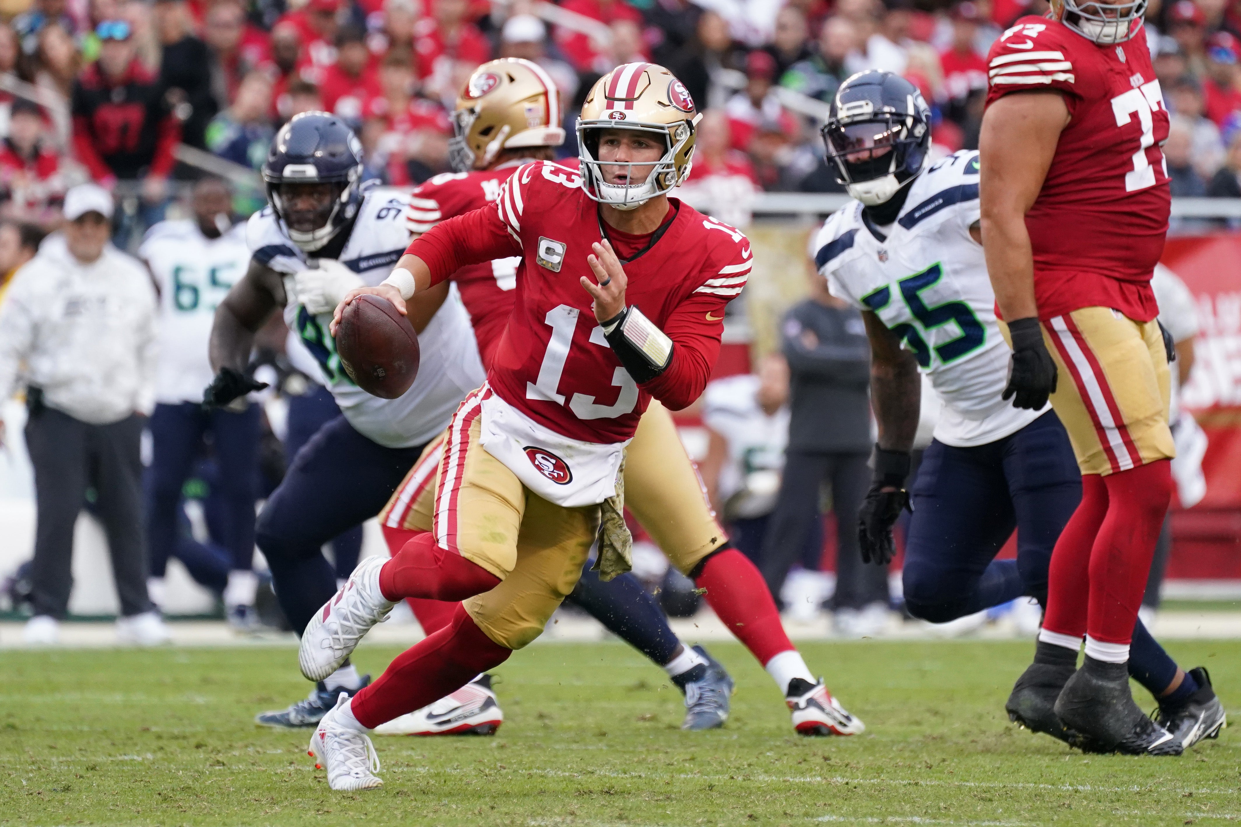 San Francisco 49ers quarterback Brock Purdy (13) scrambles away from Seattle Seahawks offensive tackle Michael Jerrell (65) in the third quarter at Levi's Stadium.