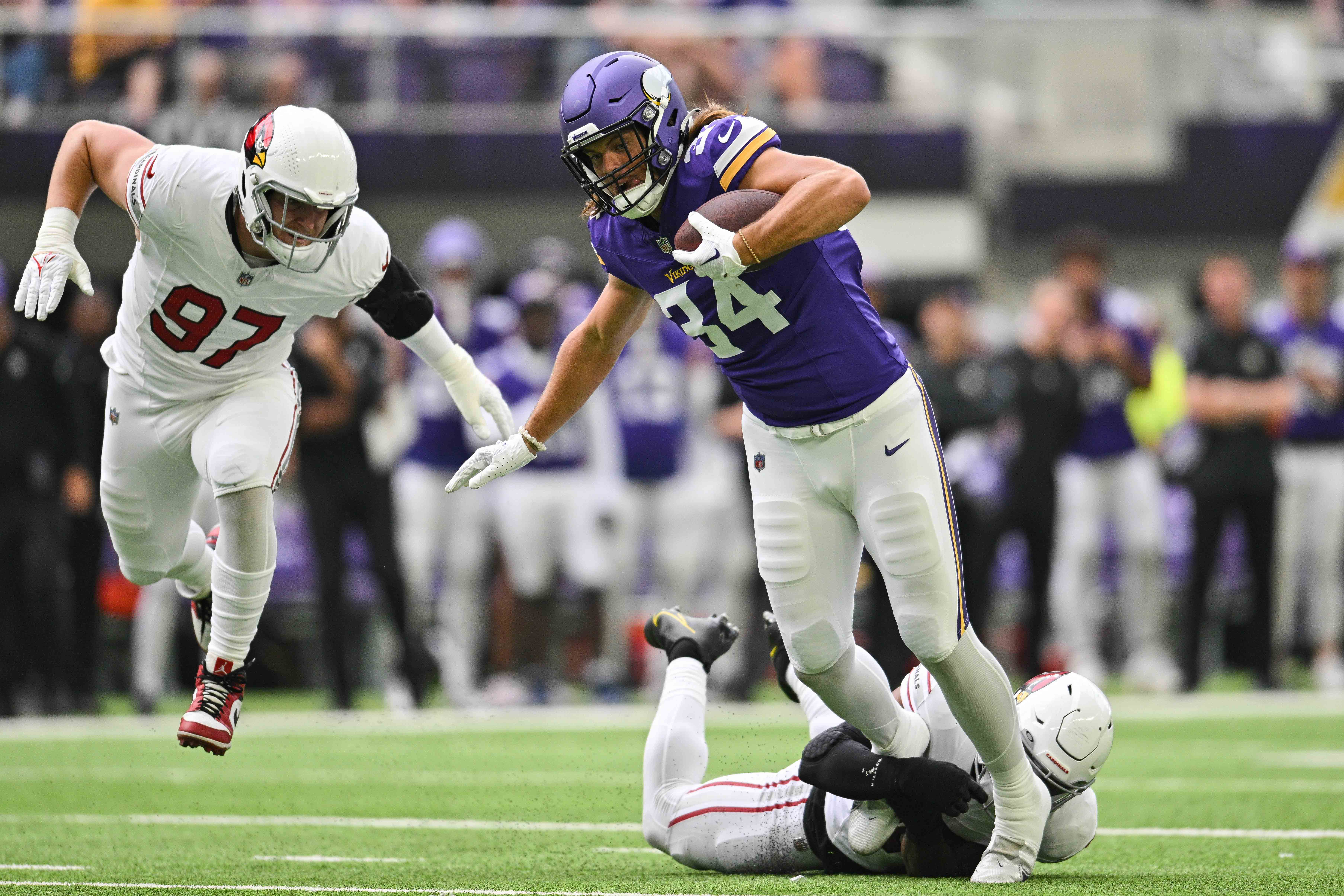 Aug 26, 2023; Minneapolis, Minnesota, USA; Minnesota Vikings tight end Nick Muse (34) runs the ball after a pass reception as Arizona Cardinals safety Jovante Moffatt (38) makes the tackle and linebacker Cameron Thomas (97) moves in during the first quarter at U.S. Bank Stadium.