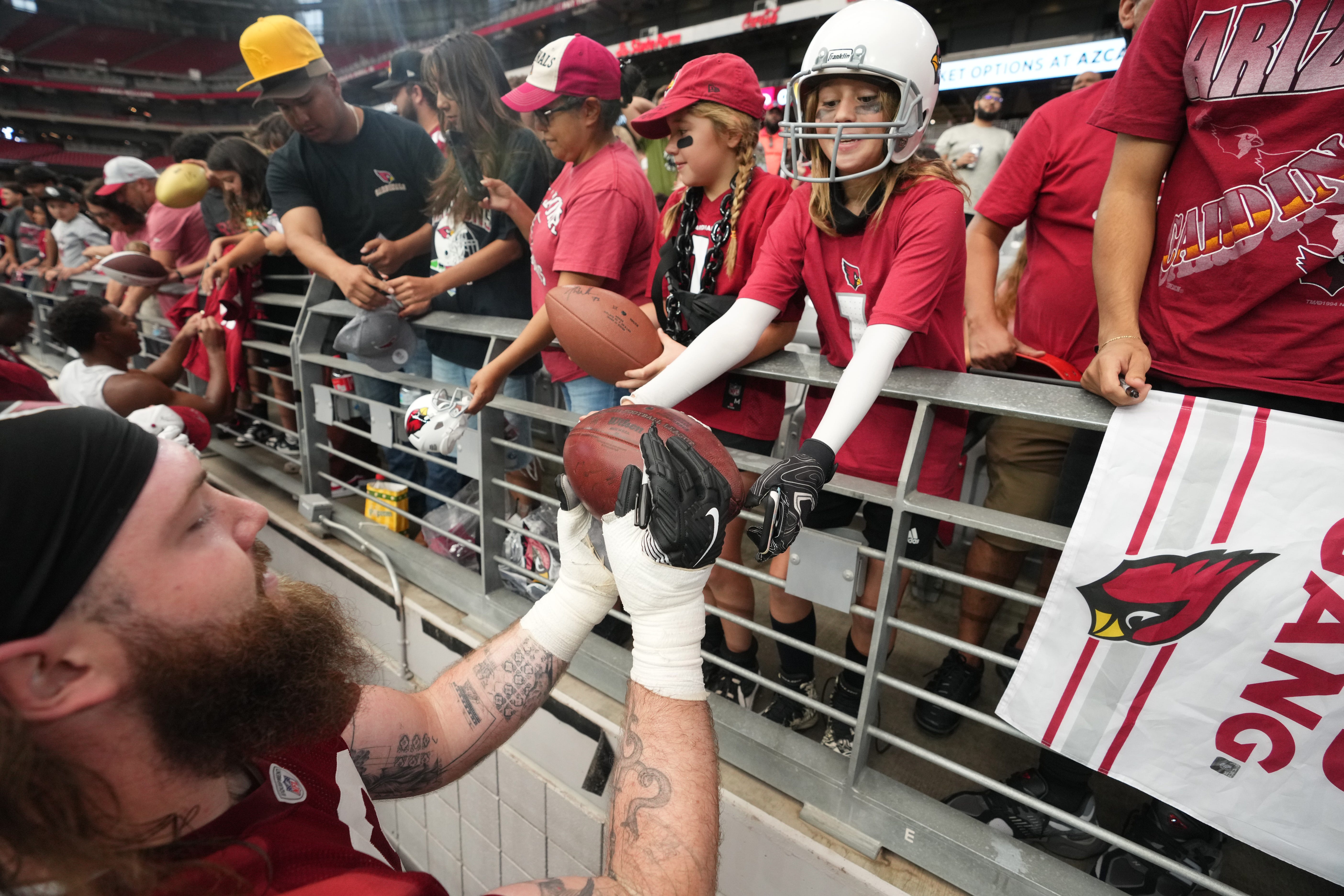 Arizona Cardinals offensive lineman Jonah Williams (73) signs autographs for fans during training camp at State Farm Stadium in Glendale on July 25, 2024.