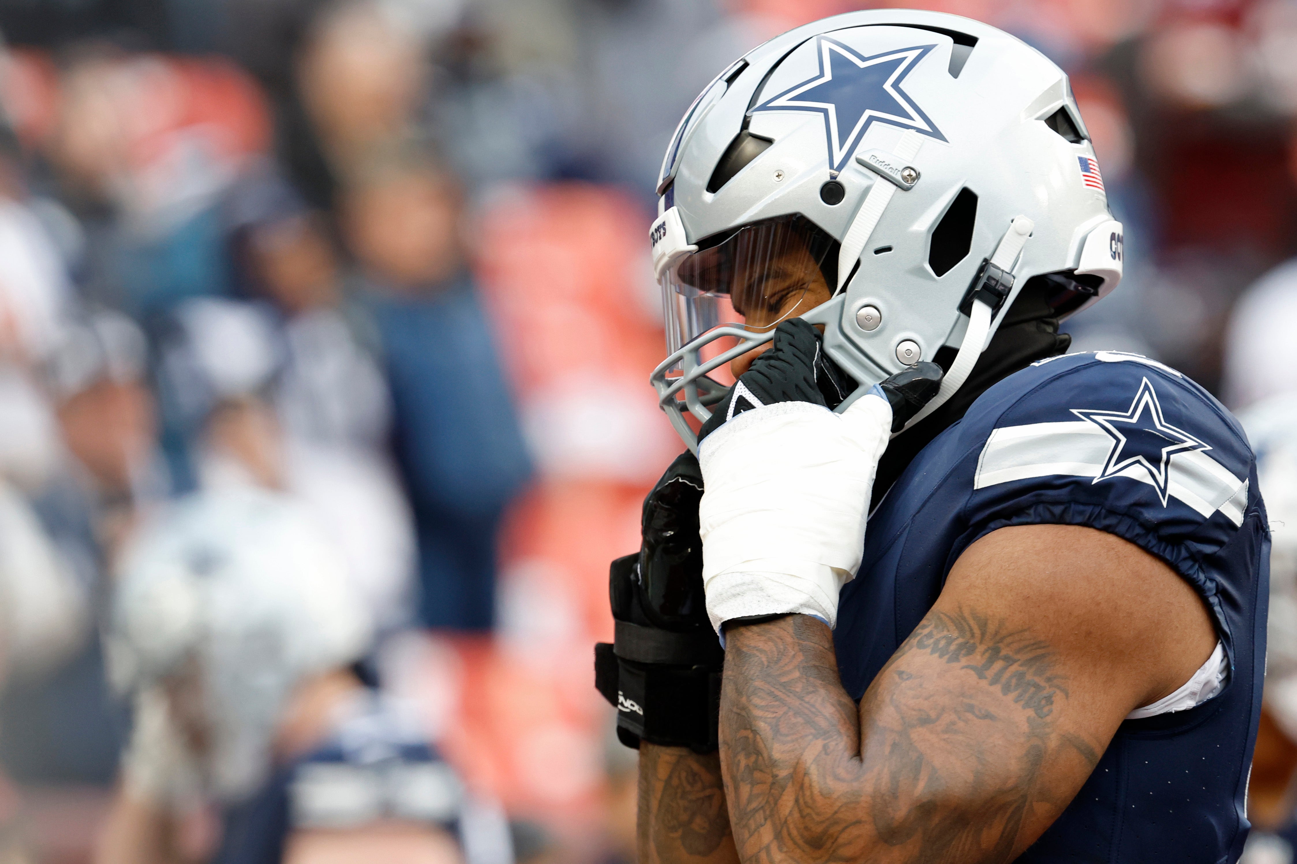 Dallas Cowboys linebacker Micah Parsons (11) adjusts his helmet during warmups prior to the game against the Washington Commanders at FedExField.