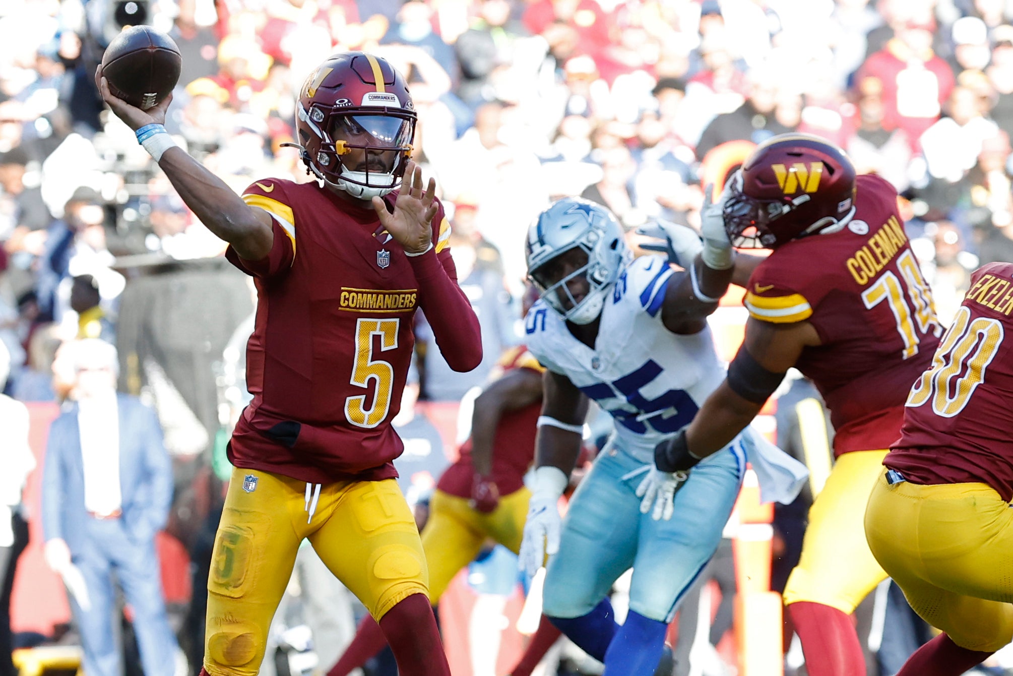 Nov 24, 2024; Landover, Maryland, USA; Washington Commanders quarterback Jayden Daniels (5) passes the ball as Dallas Cowboys defensive end Carl Lawson (55) defends during the second quarter at Northwest Stadium.