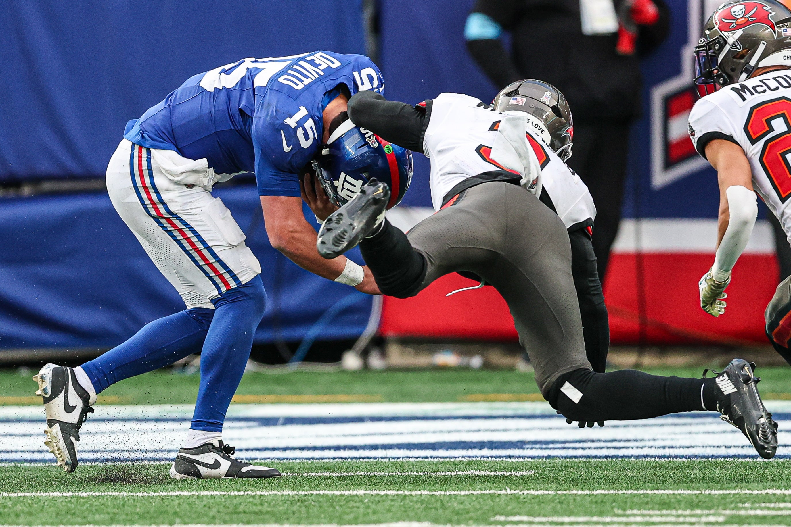 Nov 24, 2024; East Rutherford, New Jersey, USA; New York Giants quarterback Tommy DeVito (15) is tackled by Tampa Bay Buccaneers safety Jordan Whitehead (3) during the second half at MetLife Stadium.