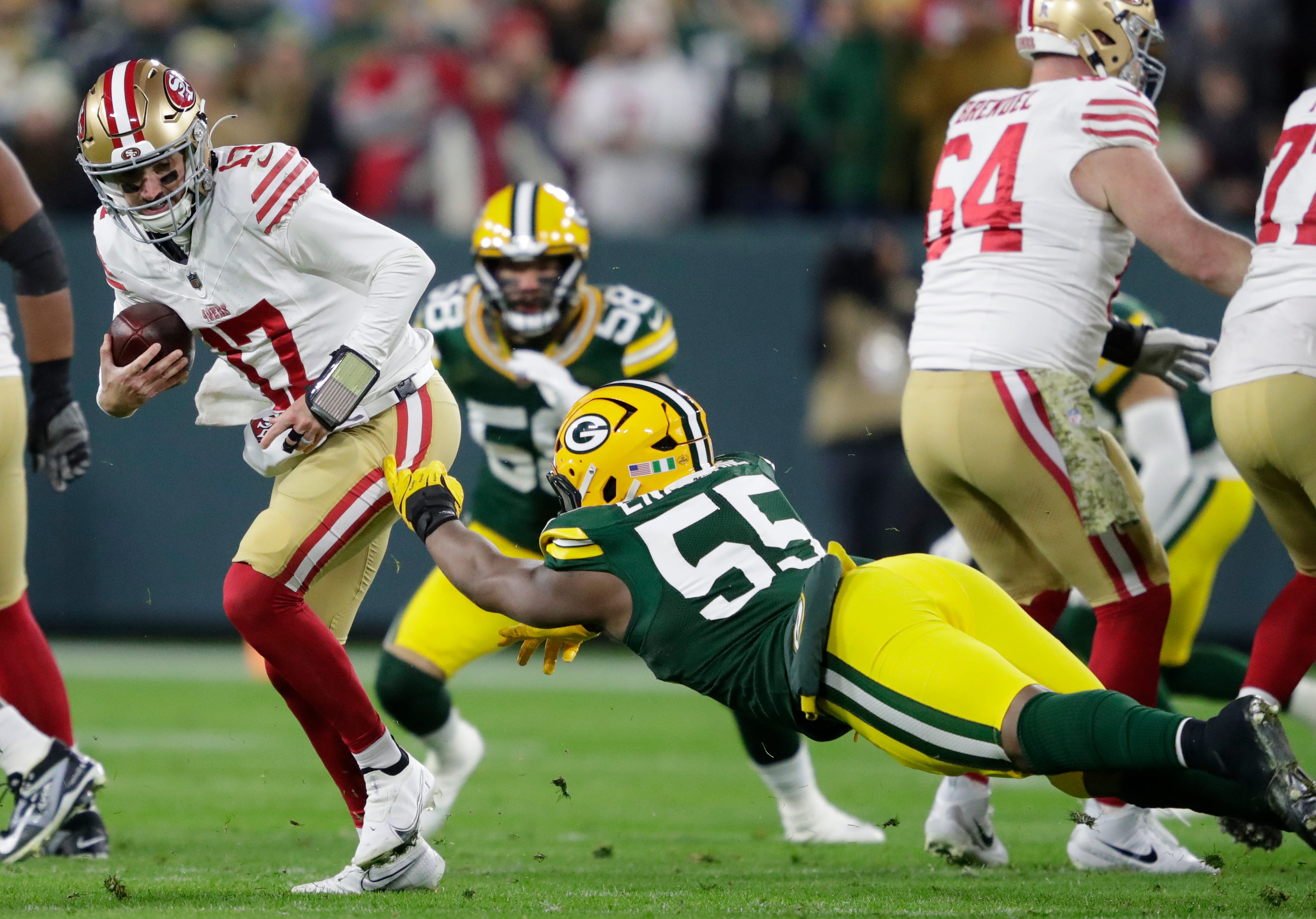 Green Bay Packers defensive end Kingsley Enagbare (55) pressures San Francisco 49ers quarterback Brandon Allen (17) during their football game Sunday, November 24, 2024, at Lambeau Field in Green Bay, Wisconsin.