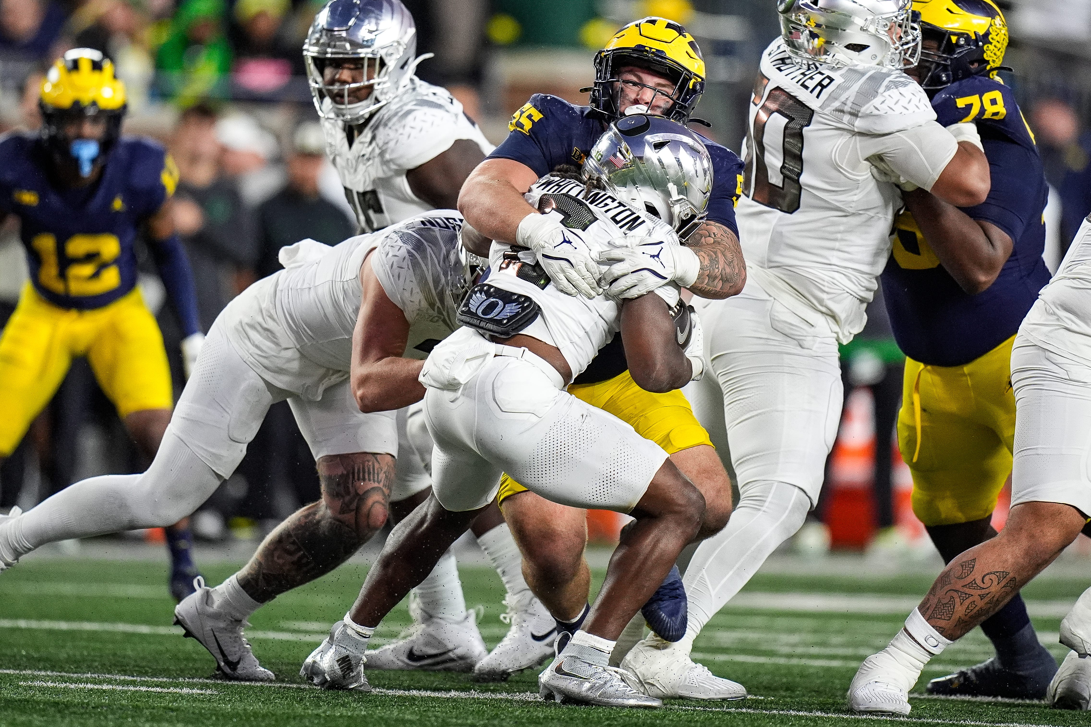Michigan defensive lineman Mason Graham (55) tackles Oregon running back Noah Whittington (6) during the second half at Michigan Stadium in Ann Arbor on Saturday, Nov. 2, 2024.