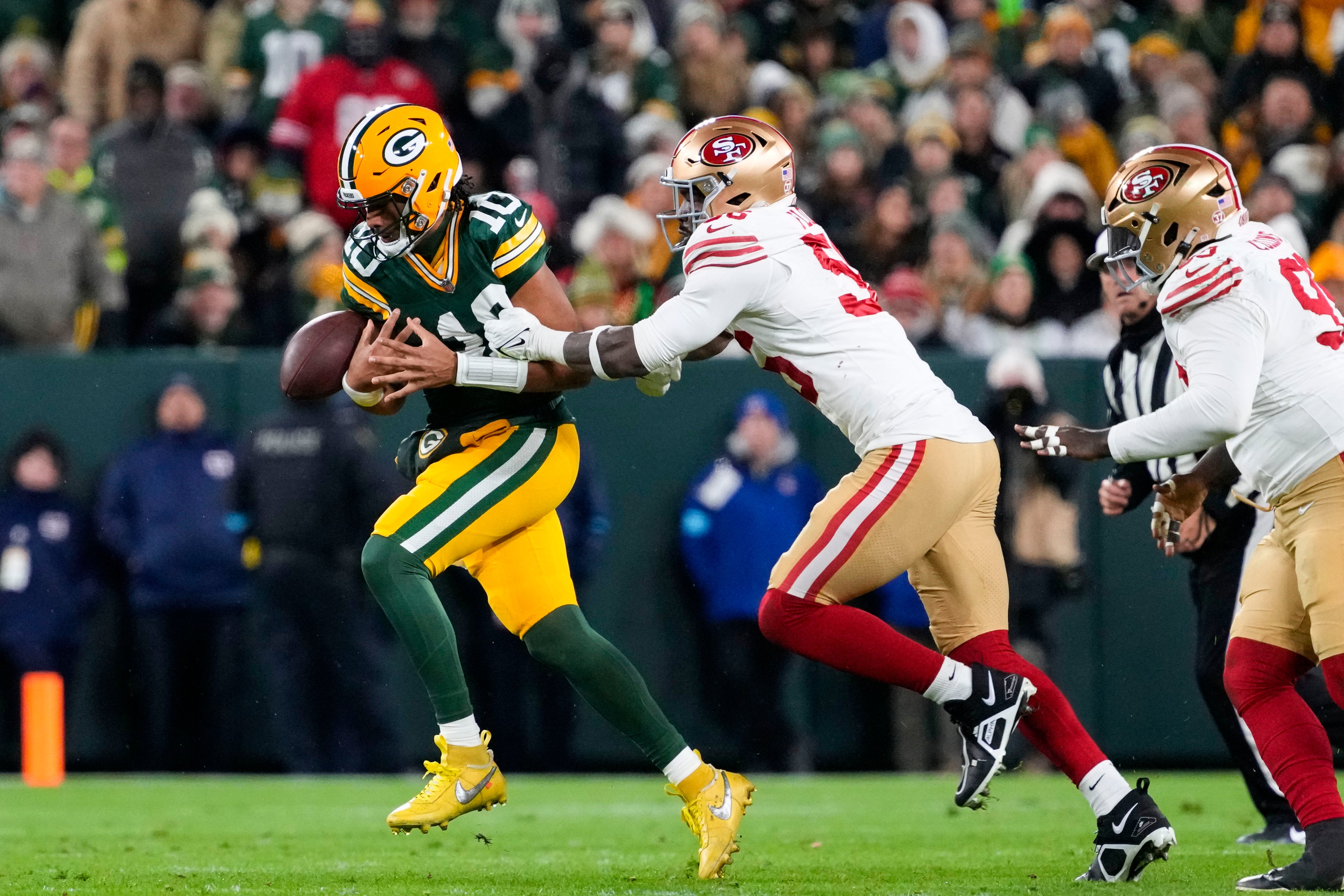 Green Bay Packers quarterback Jordan Love (10) loses control of the football while under pressure from San Francisco 49ers defensive end Leonard Floyd (56) during the fourth quarter at Lambeau Field.