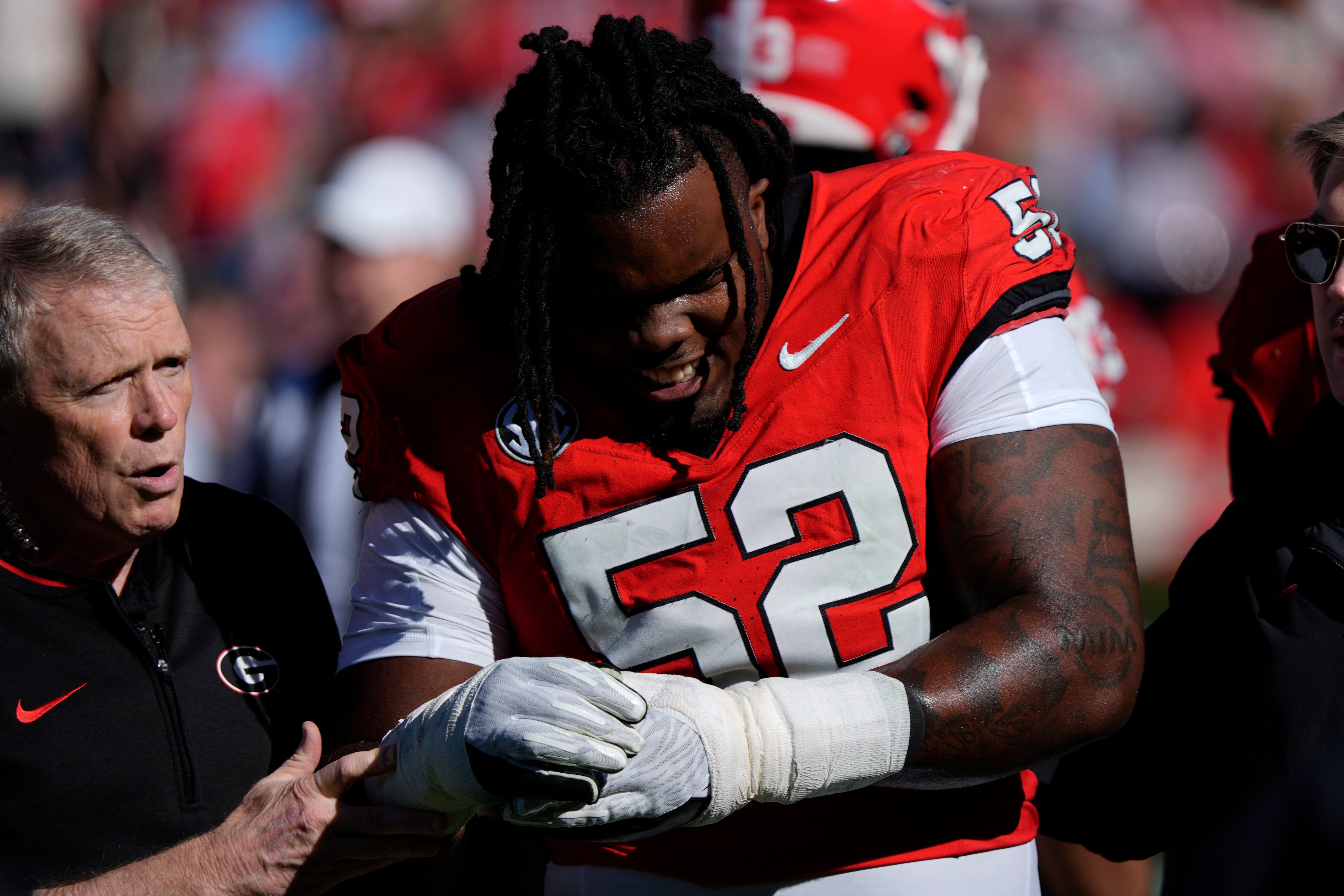 Georgia defensive lineman Christen Miller (52) leaves the field with an injury during the first half of a NCAA college football game against Massachusetts in Athens, Ga., on Saturday, Nov. 23, 2024.