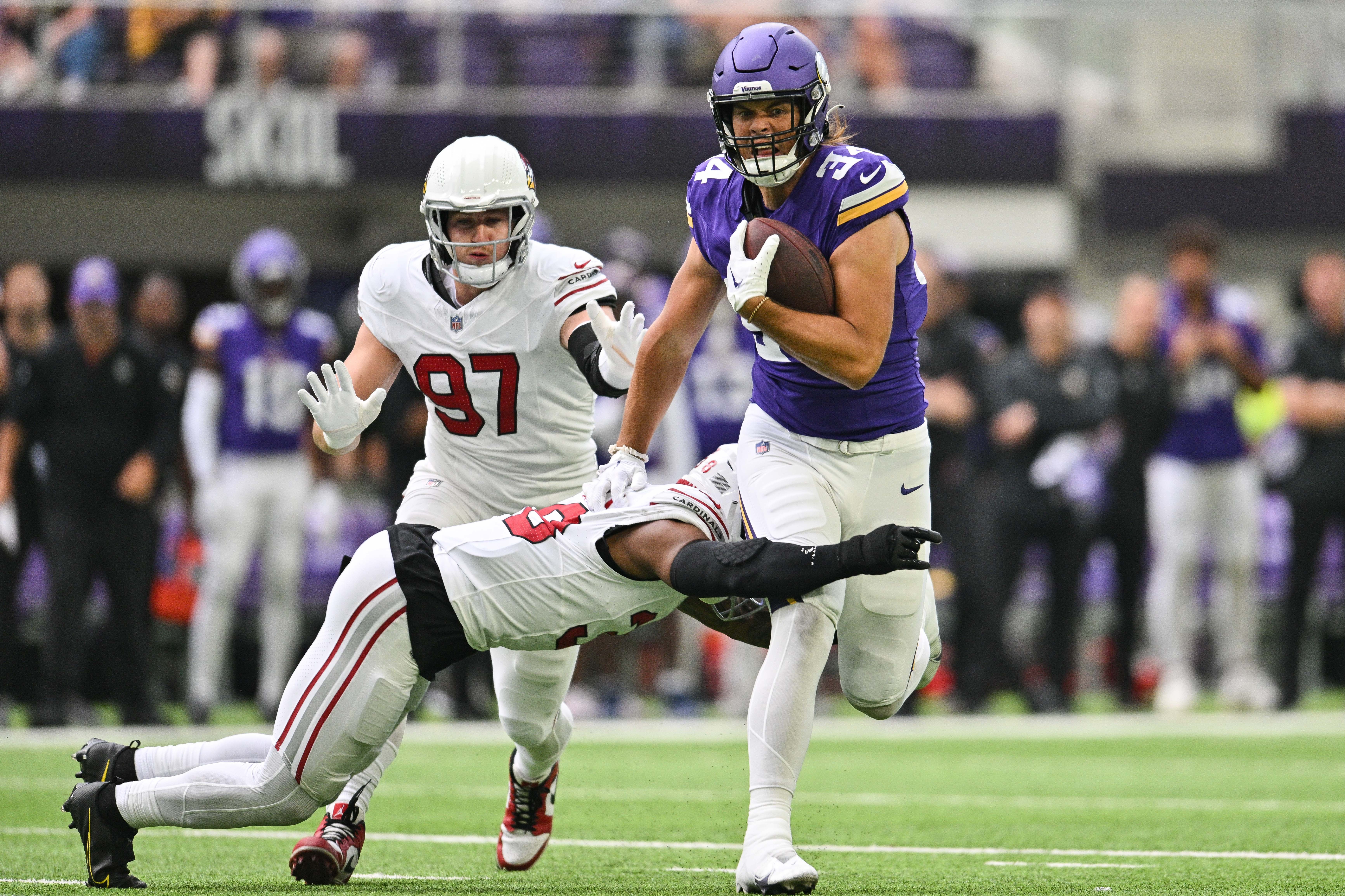Aug 26, 2023; Minneapolis, Minnesota, USA; Minnesota Vikings tight end Nick Muse (34) runs the ball after a pass reception against Arizona Cardinals safety Jovante Moffatt (38) and linebacker Cameron Thomas (97) during the first quarter at U.S. Bank Stadium.