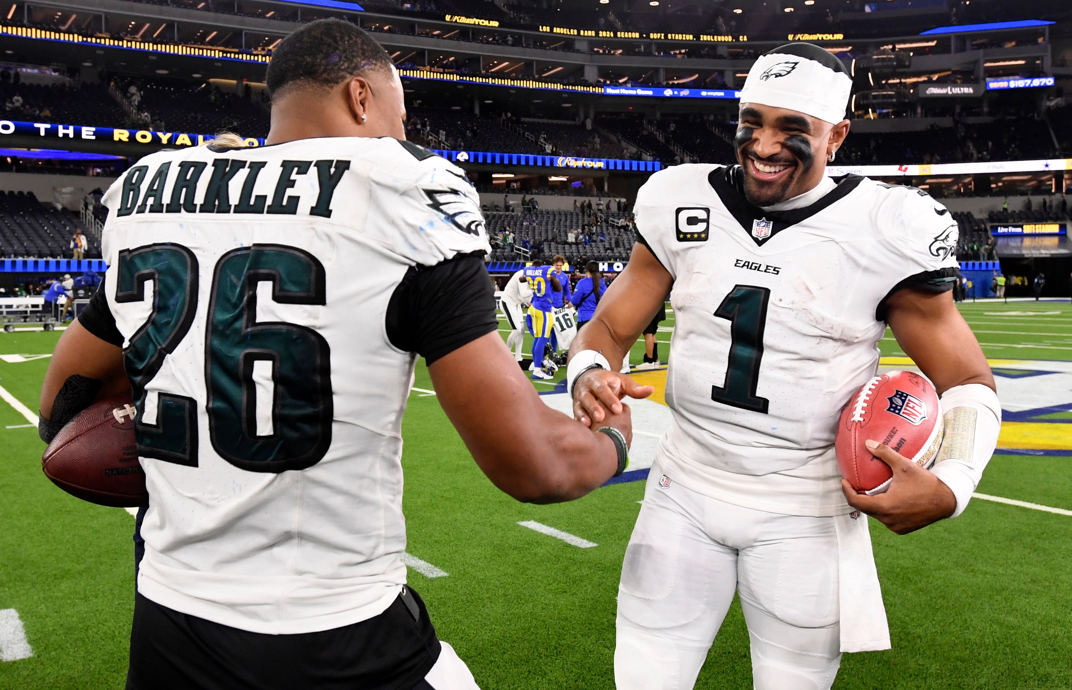 Philadelphia Eagles quarterback Jalen Hurts (1) celebrates with running back Saquon Barkley (26) after the Eagles defeat the Los Angeles Rams during the first half at SoFi Stadium.
