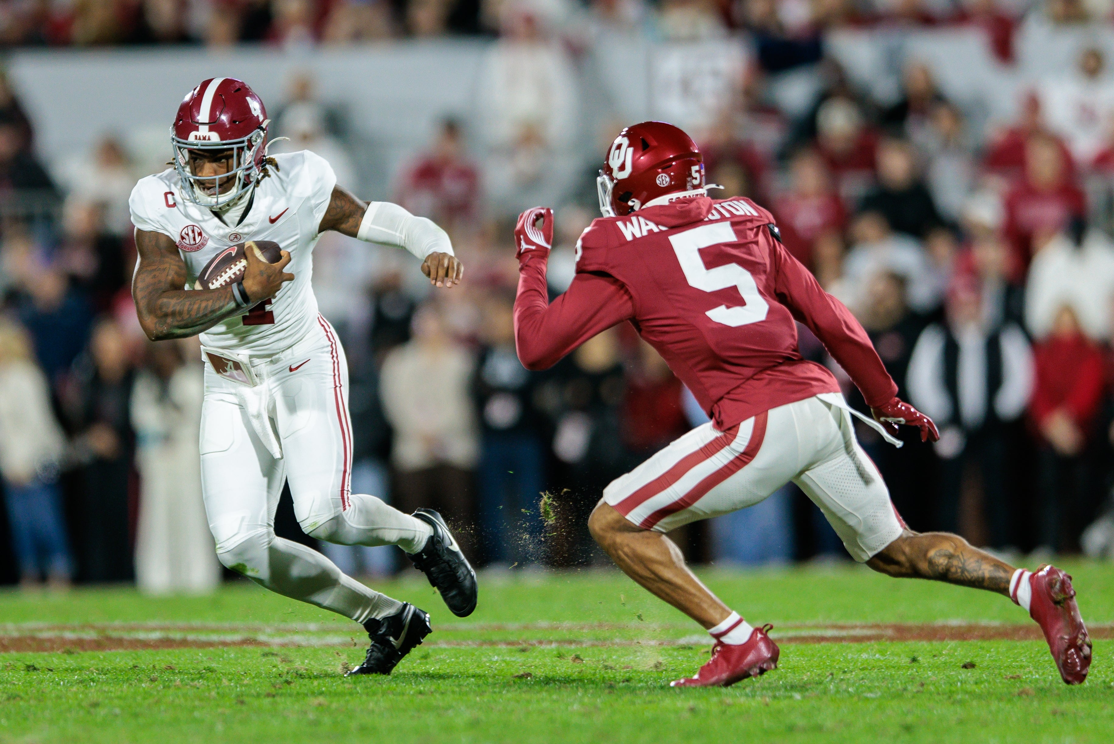 Nov 23, 2024; Norman, Oklahoma, USA; Alabama Crimson Tide quarterback Jalen Milroe (4) runs the ball around Oklahoma Sooners defensive back Woodi Washington (5) during the third quarter at Gaylord Family-Oklahoma Memorial Stadium.