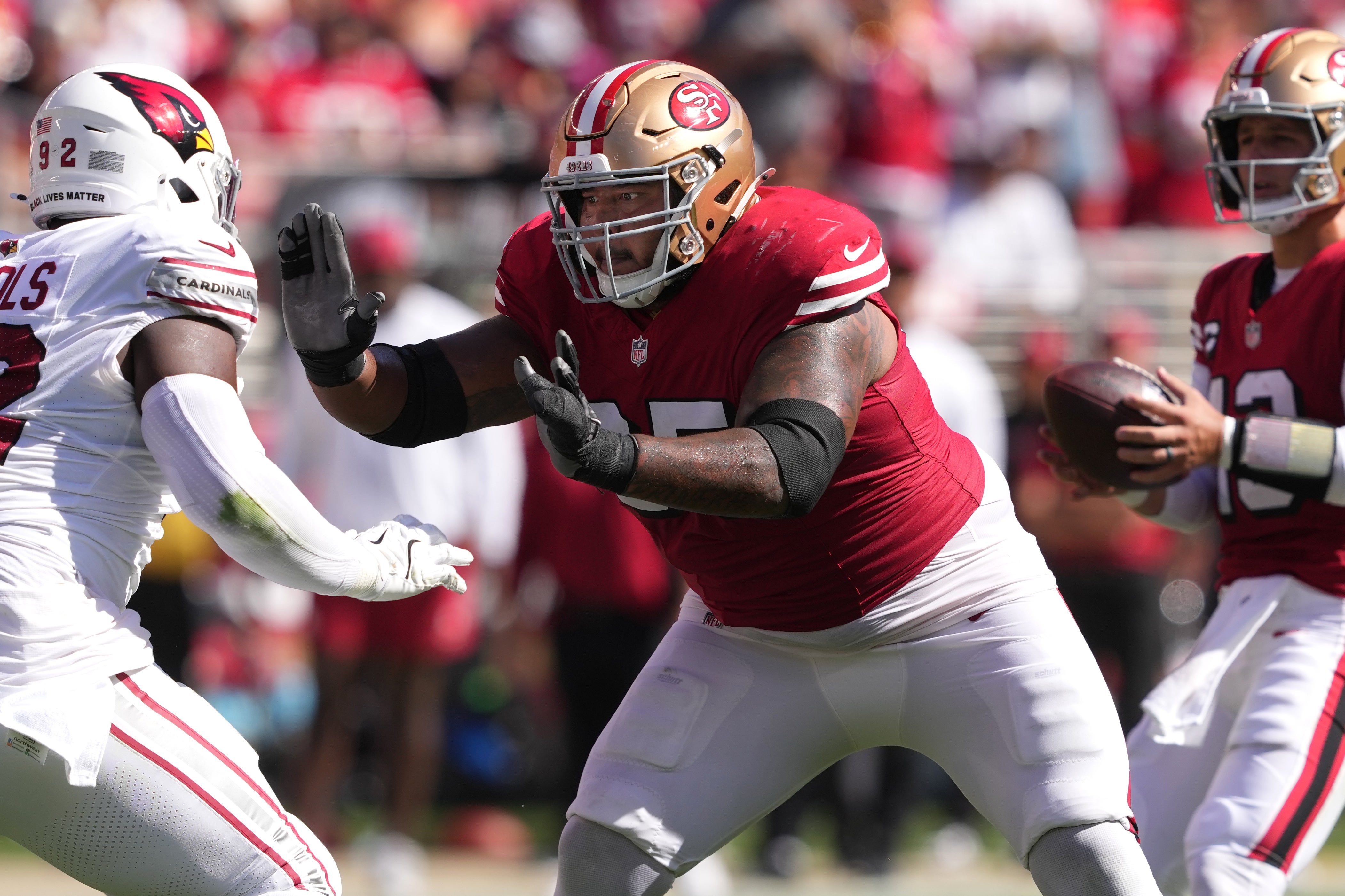 San Francisco 49ers guard Aaron Banks (center) blocks against Arizona Cardinals defensive tackle Bilal Nichols (left) during the second quarter at Levi's Stadium.