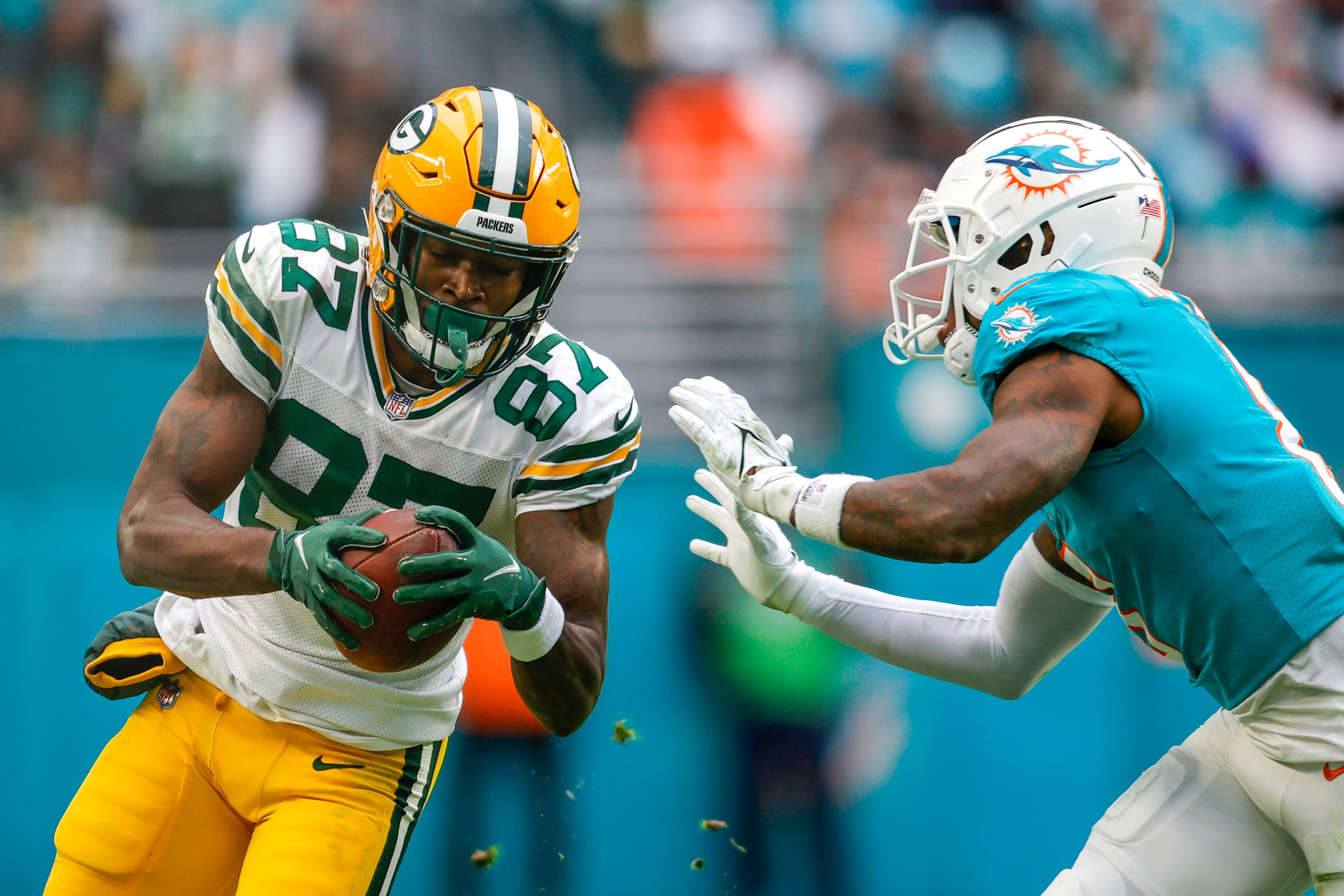 Dec 25, 2022; Miami Gardens, Florida, USA; Green Bay Packers wide receiver Romeo Doubs (87) runs with the football as Miami Dolphins safety Jevon Holland (8) attempts a tackle during the fourth quarter at Hard Rock Stadium