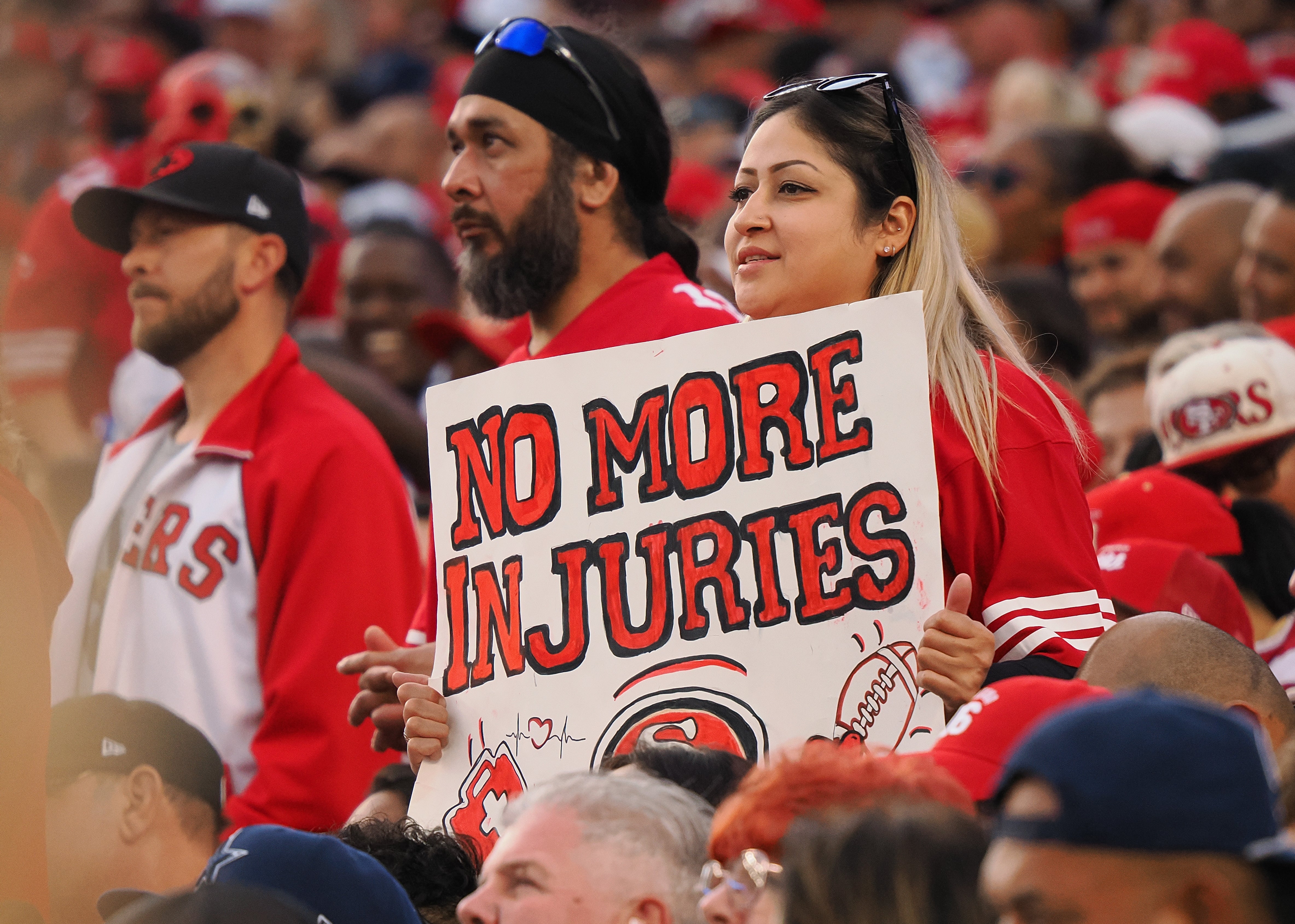 A San Francisco 49ers fan holds a sign reading “no more injuries” during the first quarter against the Dallas Cowboys at Levi's Stadium.