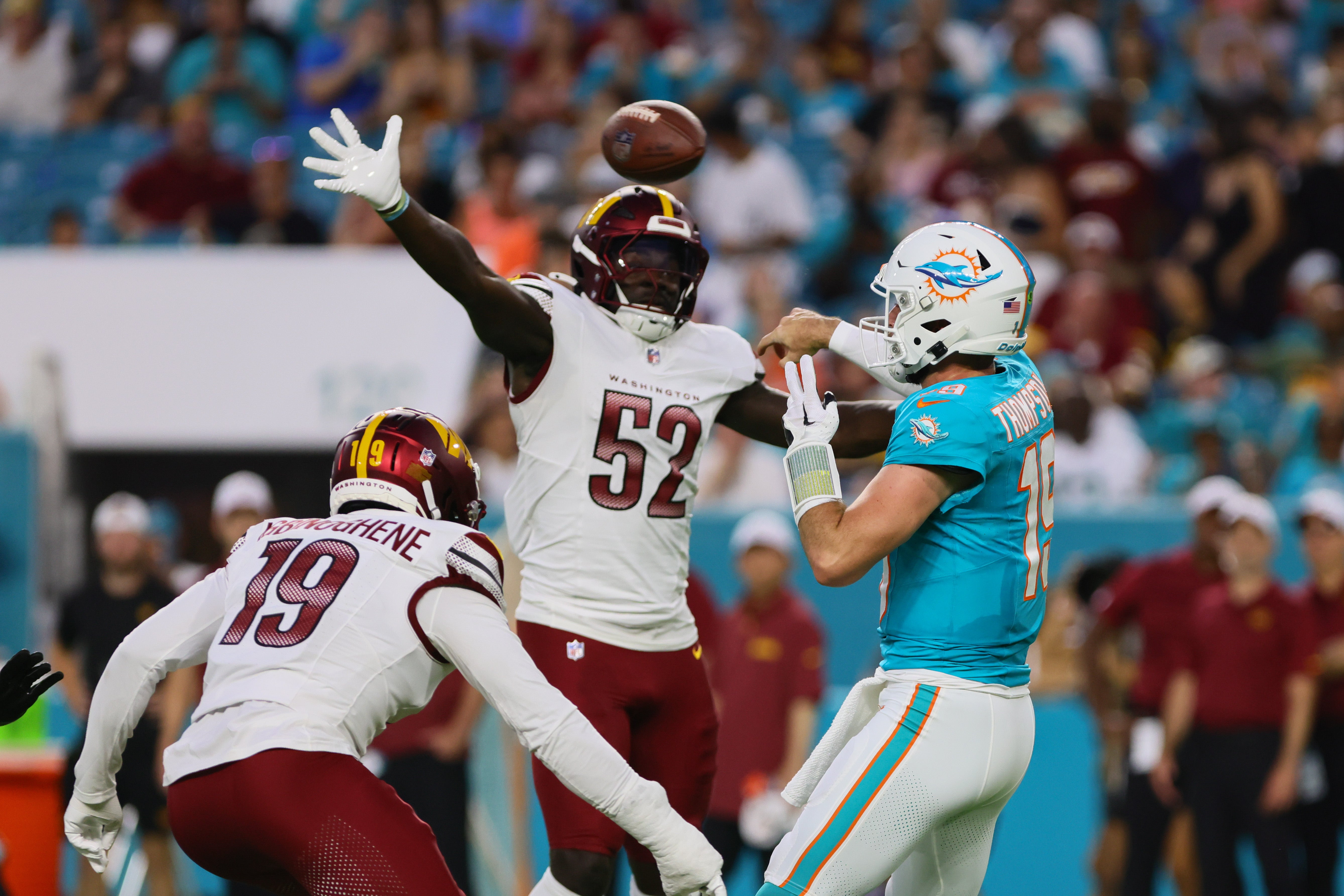 Aug 17, 2024; Miami Gardens, Florida, USA; Miami Dolphins quarterback Skylar Thompson (19) throws the football as Washington Commanders linebacker Jamin Davis (52) defends during the second quarter of a preseason game at Hard Rock Stadium.