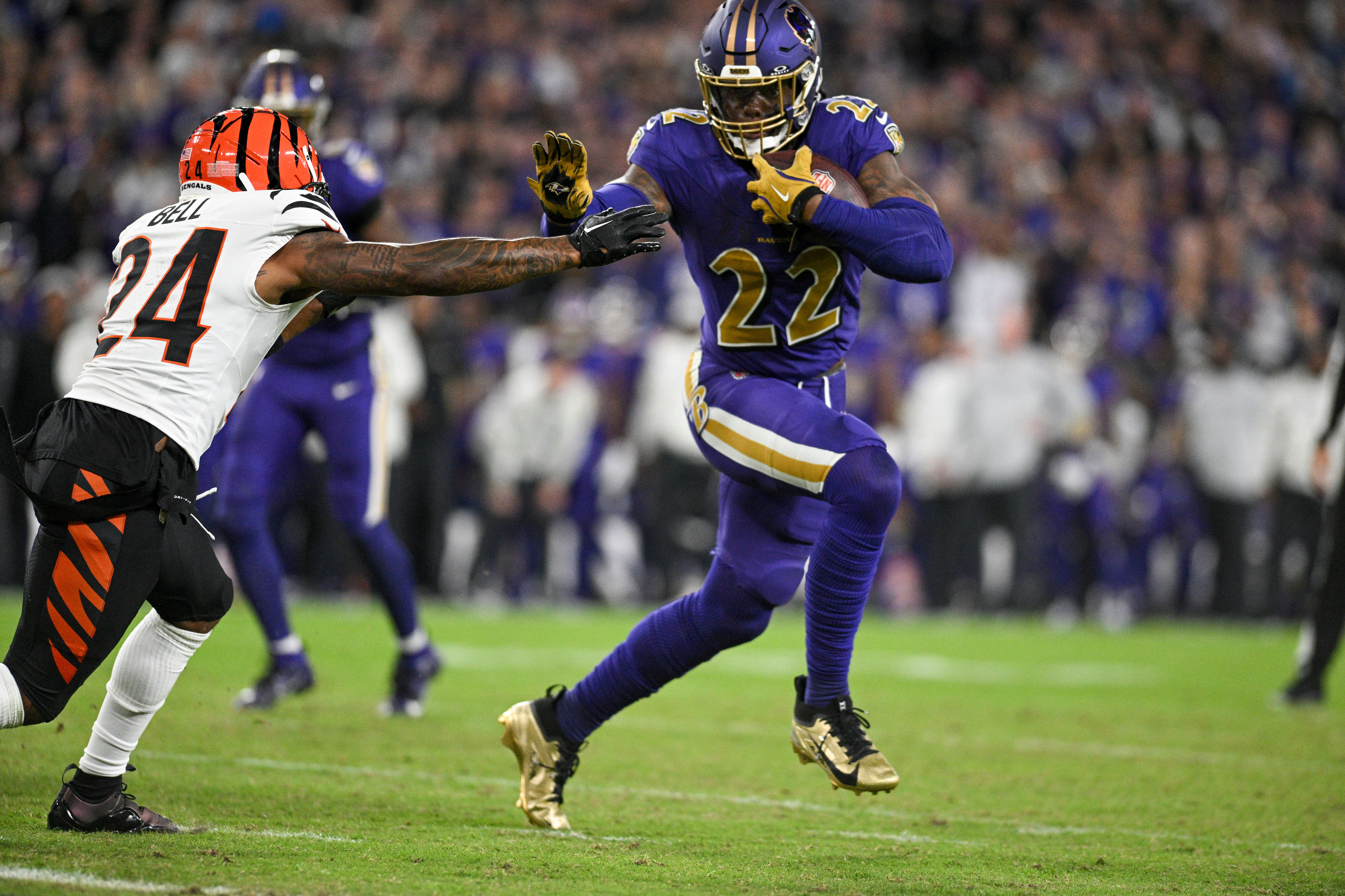 Ravens running back Derrick Henry (22) pushes Bengals safety Vonn Bell (24) arms away.