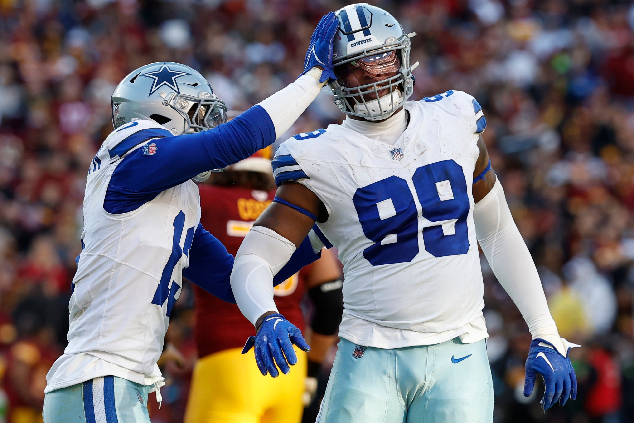 Dallas Cowboys defensive end Chauncey Golston (99) celebrates with Cowboys linebacker DeMarvion Overshown (13) after batting down a pass against the Washington Commanders during the third quarter at Northwest Stadium.