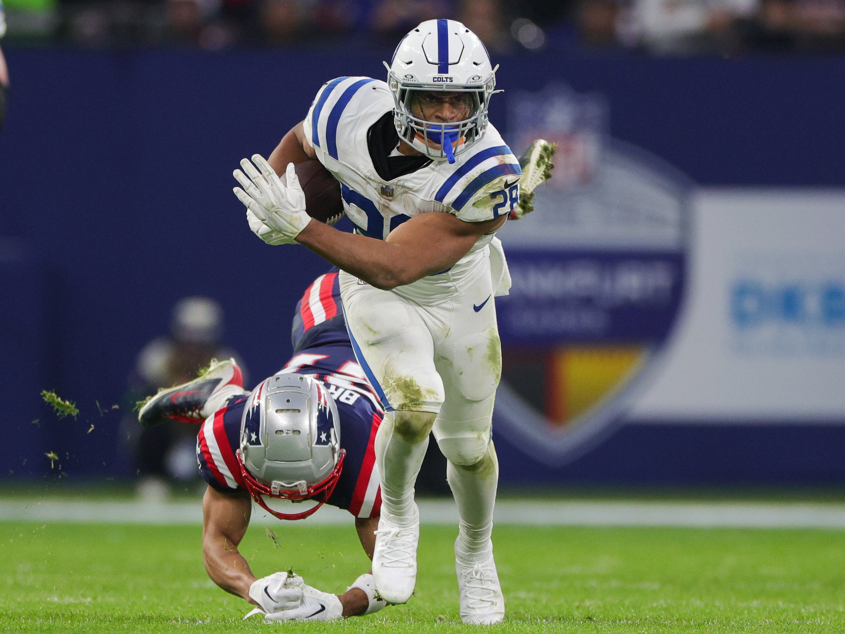 Nov 12, 2023; Frankfurt, Germany; Indianapolis Colts running back Jonathan Taylor (28) breaks a tackle from New England Patriots cornerback Myles Bryant (27) in the second quarter during an International Series game at Deutsche Bank Park.