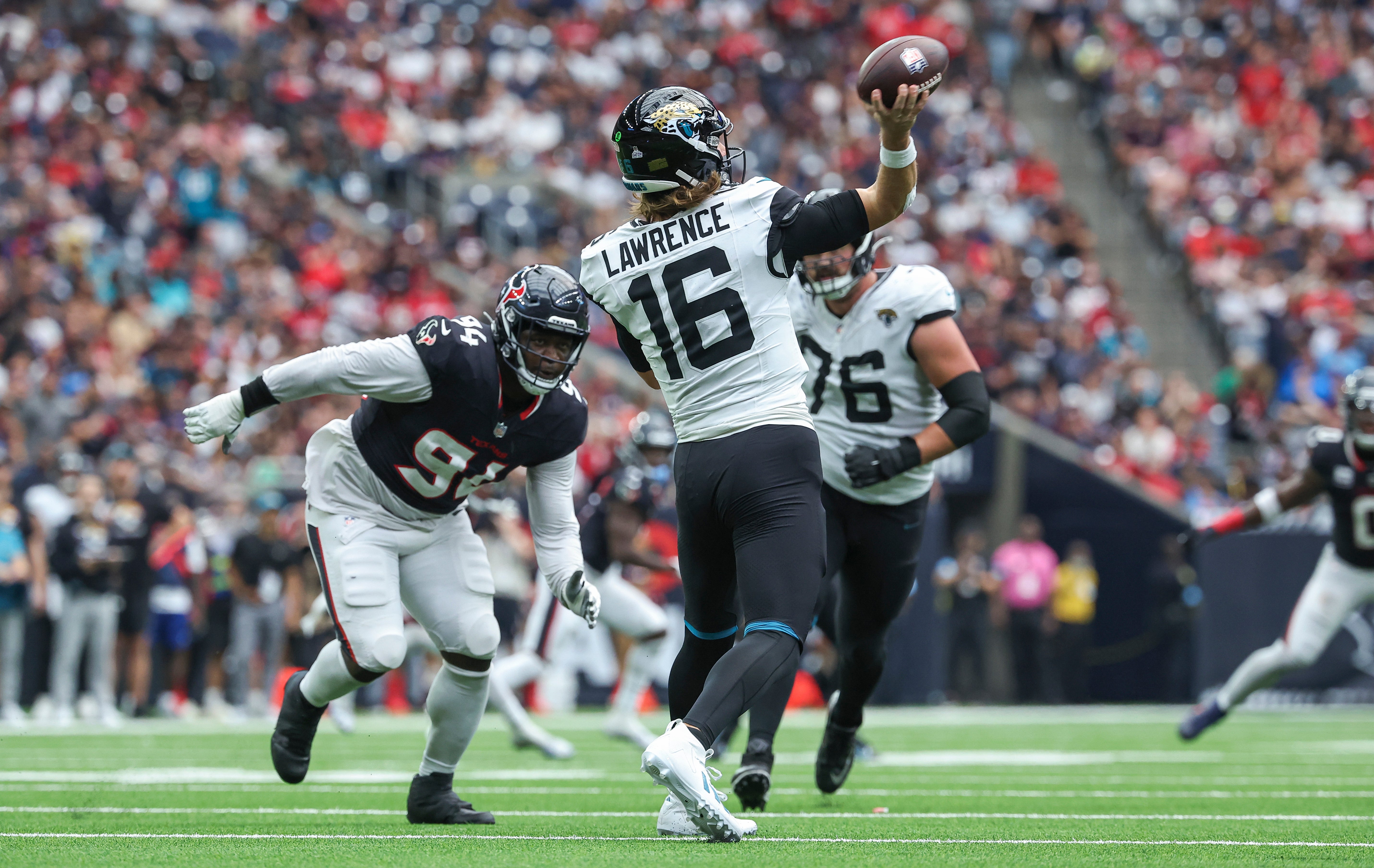 Sep 29, 2024; Houston, Texas, USA; Jacksonville Jaguars quarterback Trevor Lawrence (16) attempts a pass as Houston Texans defensive tackle Khalil Davis (94) applies defensive pressure at NRG Stadium.