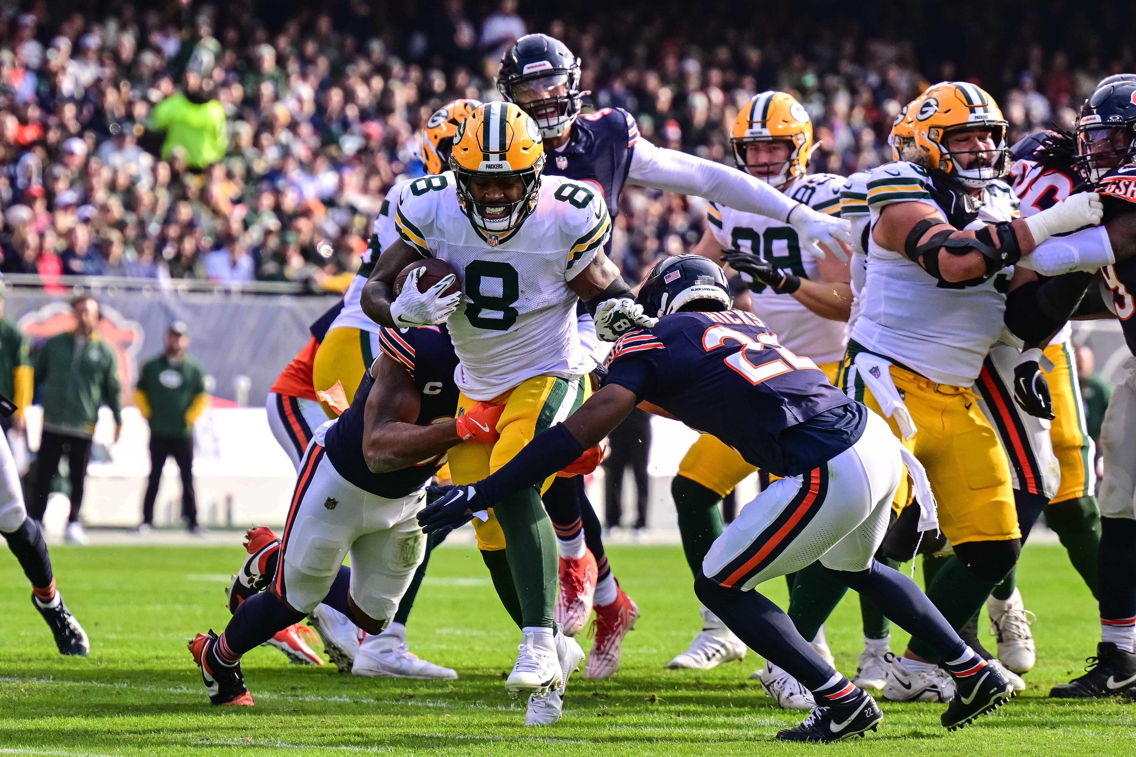 Green Bay Packers running back Josh Jacobs (8) runs the ball and is tackled by Chicago Bears free safety Kevin Byard (31) and safety Elijah Hicks (22) during the second quarter at Soldier Field.