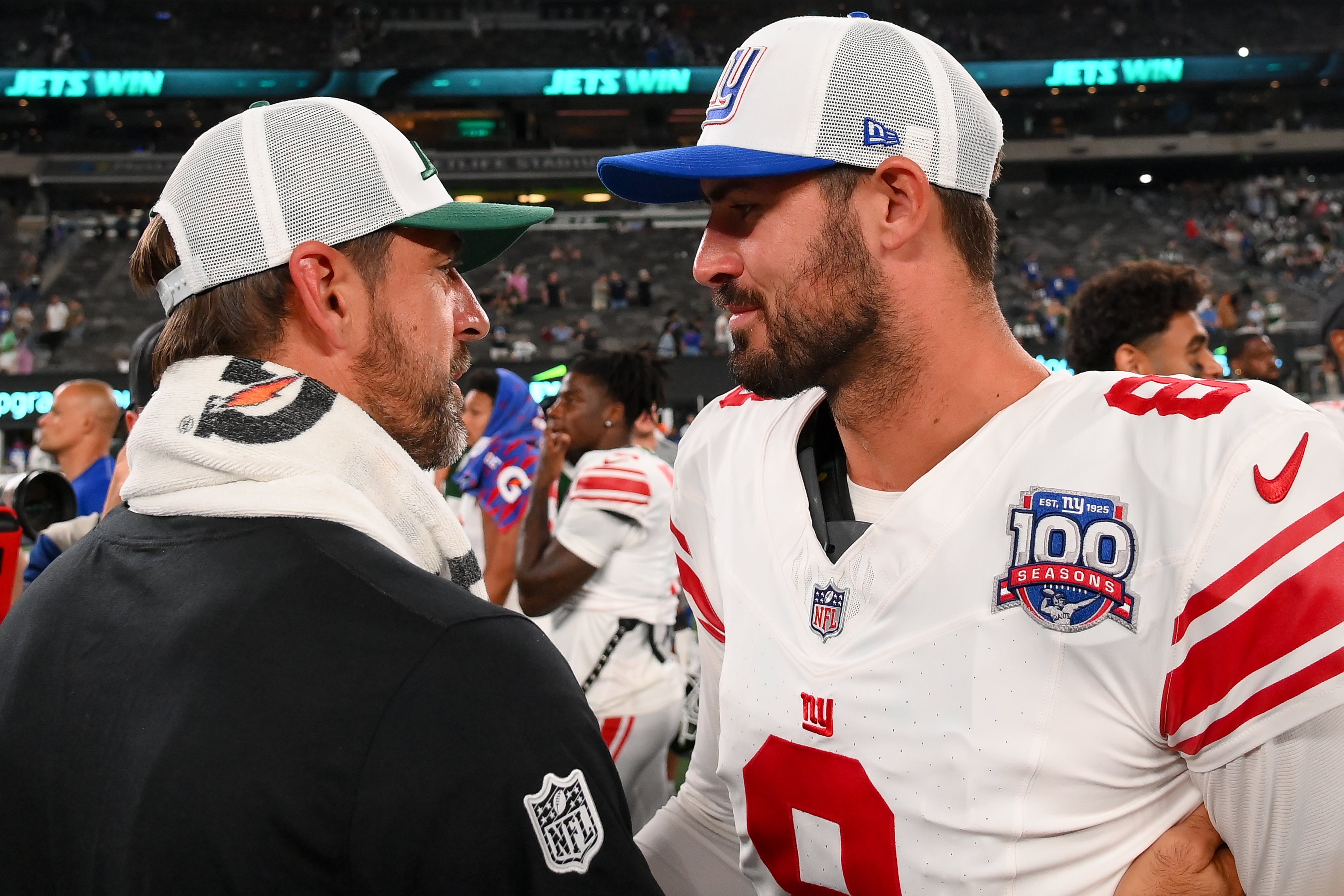Aug 24, 2024; East Rutherford, New Jersey, USA; New York Jets quarterback Aaron Rodgers (left) and New York Giants quarterback Daniel Jones (right) meet following the game at MetLife Stadium.