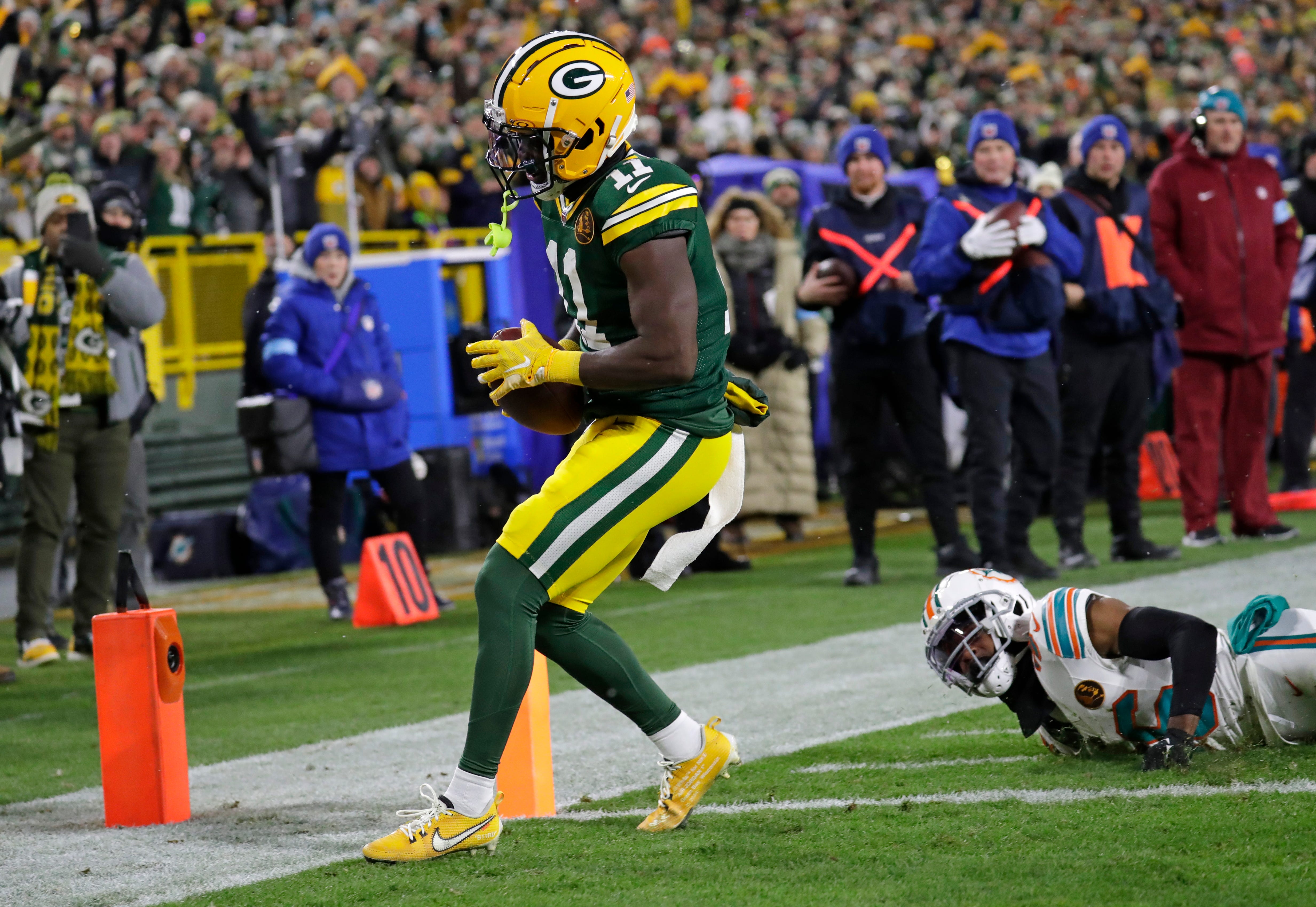 Green Bay Packers wide receiver Jayden Reed (11) scores a touchdown against Miami Dolphins cornerback Storm Duck (36) in the first quarter during their football game Thursday, November 28, 2024, at Lambeau Field in Green Bay, Wisconsin.