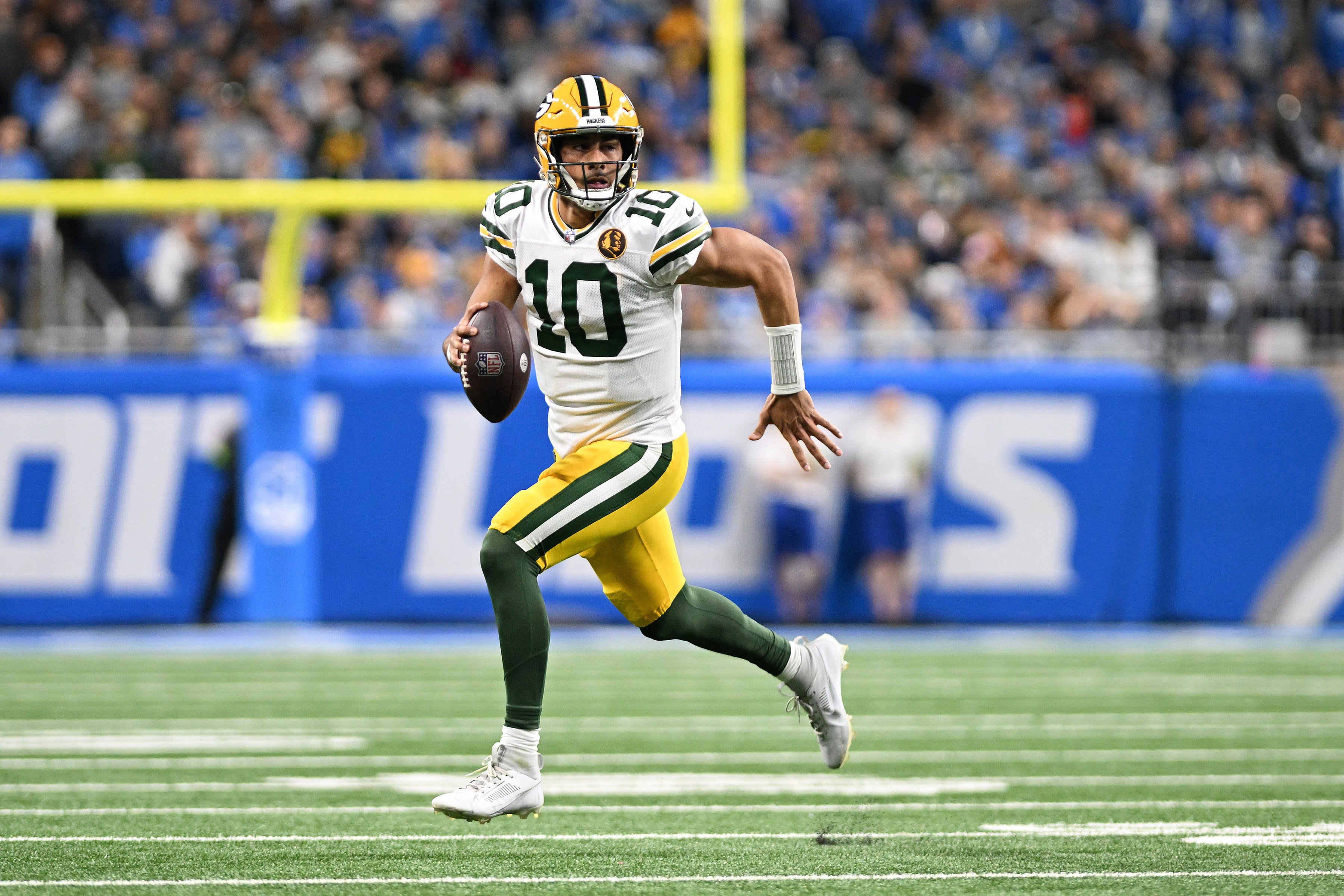 Green Bay Packers quarterback Jordan Love (10) runs out of the pocket against the Detroit Lions in the first quarter at Ford Field.