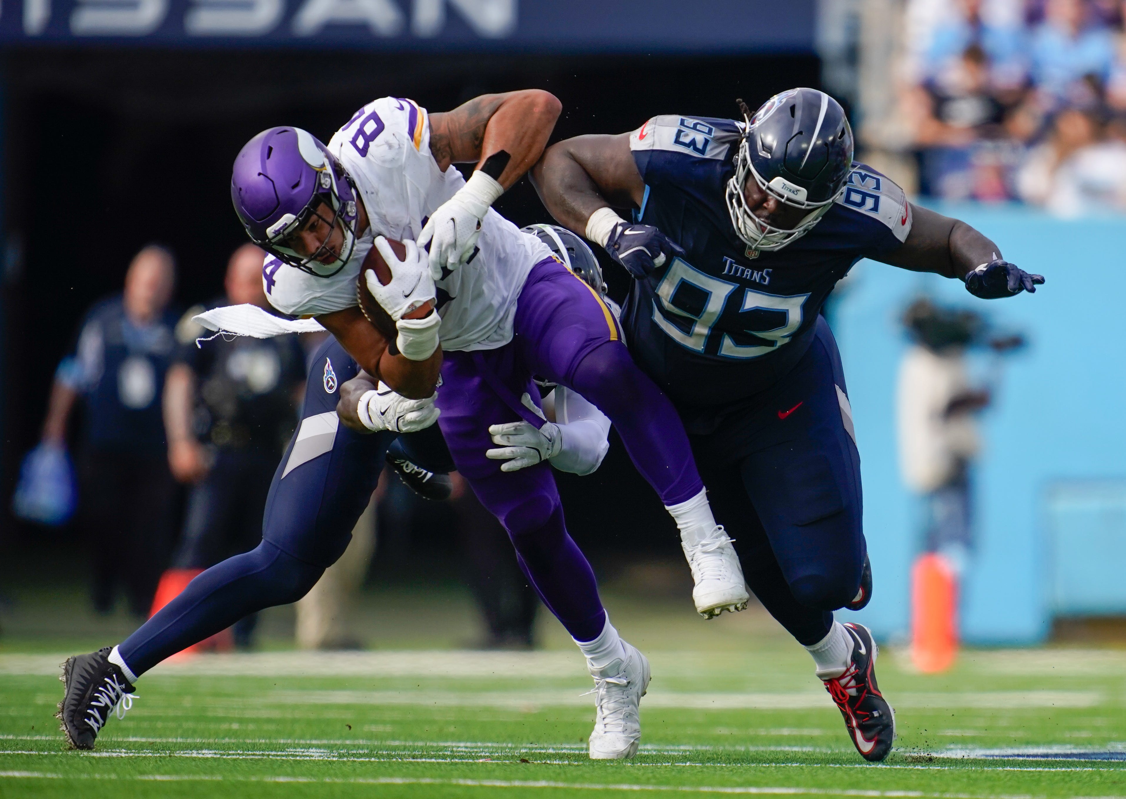 Tennessee Titans linebacker Kenneth Murray Jr. (56) and defensive tackle T'Vondre Sweat (93) tackle Minnesota Vikings tight end Josh Oliver (84) during the second quarter at Nissan Stadium in Nashville, Tenn., Sunday, Nov. 17, 2024.