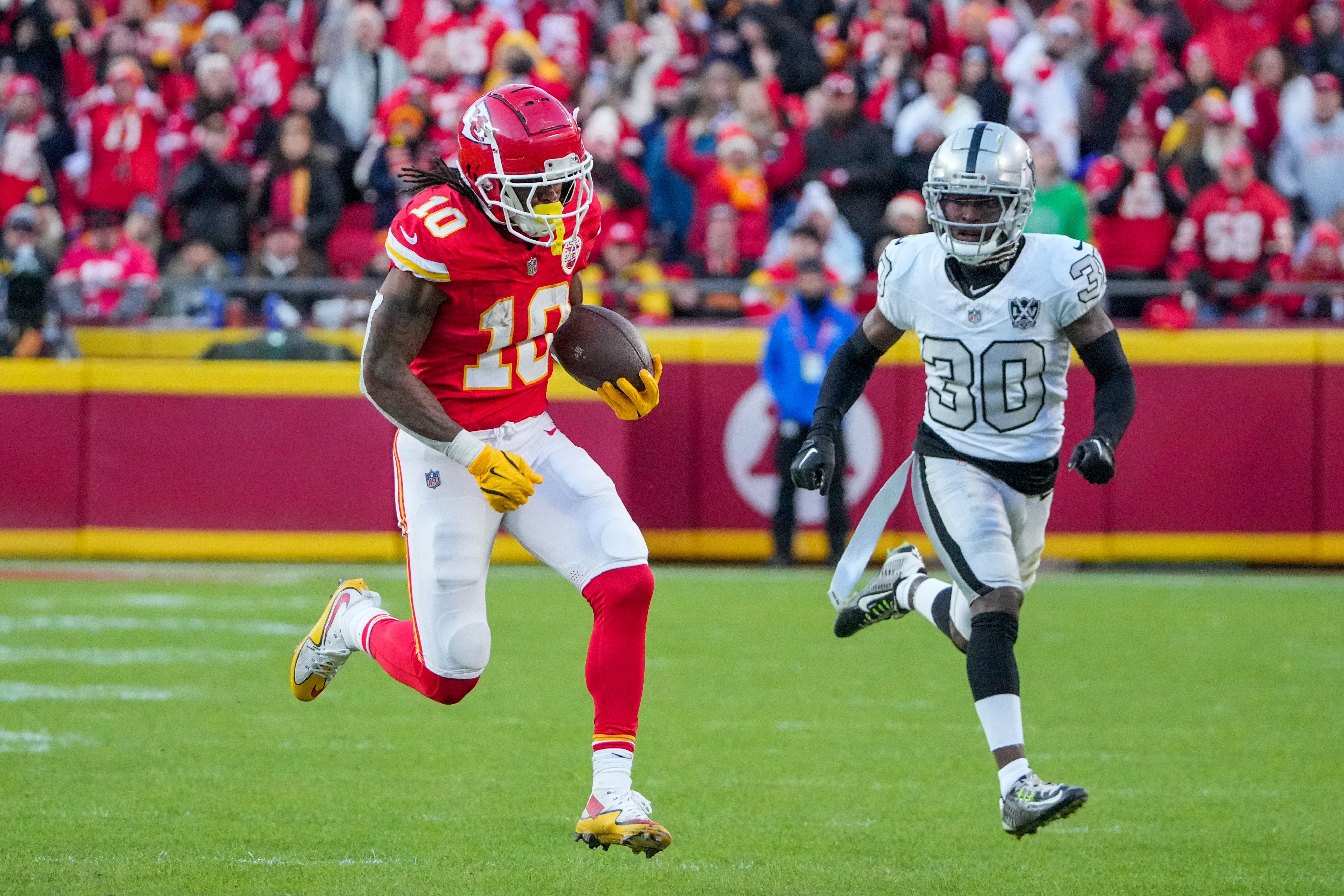 Nov 29, 2024; Kansas City, Missouri, USA; Kansas City Chiefs running back Isiah Pacheco (10) runs the ball as Las Vegas Raiders cornerback Darnay Holmes (30) chases during the second half at GEHA Field at Arrowhead Stadium.