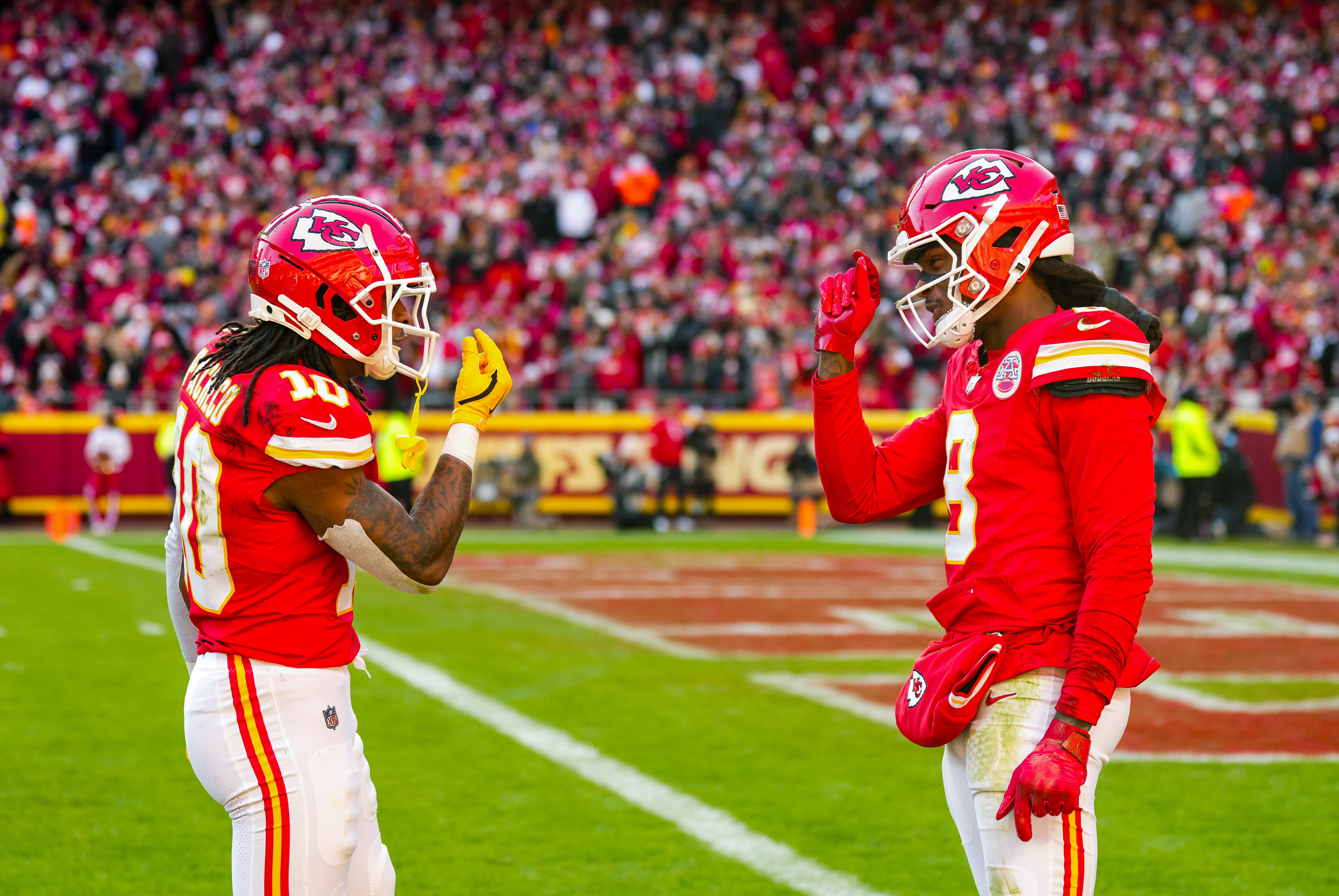 Nov 29, 2024; Kansas City, Missouri, USA; Kansas City Chiefs running back Isiah Pacheco (10) and wide receiver DeAndre Hopkins (8) react after a play during the first half against the Las Vegas Raiders at GEHA Field at Arrowhead Stadium.