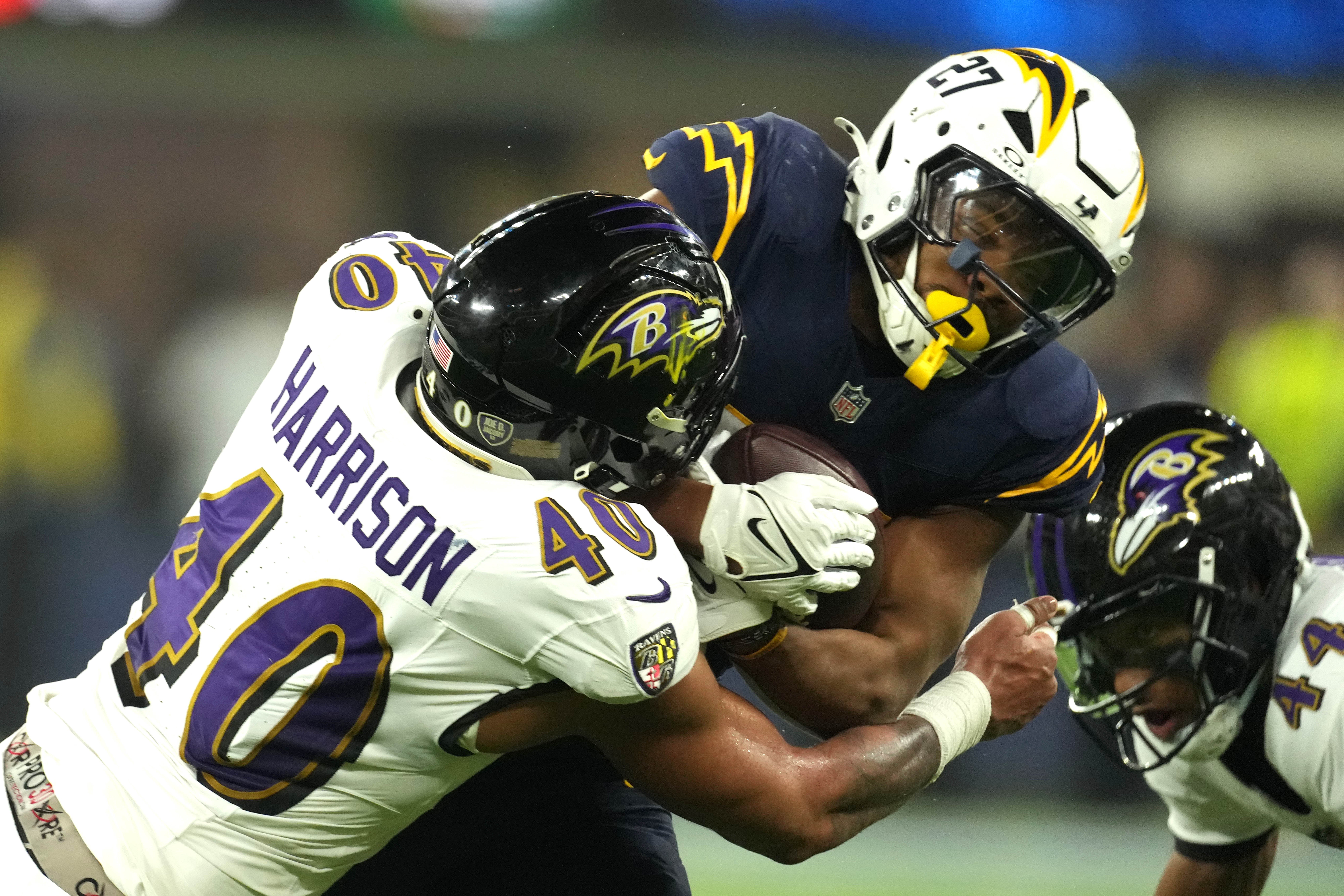 Los Angeles Chargers running back J.K. Dobbins (27) carries the ball against Baltimore Ravens linebacker Malik Harrison (40) in the first half at SoFi Stadium. 