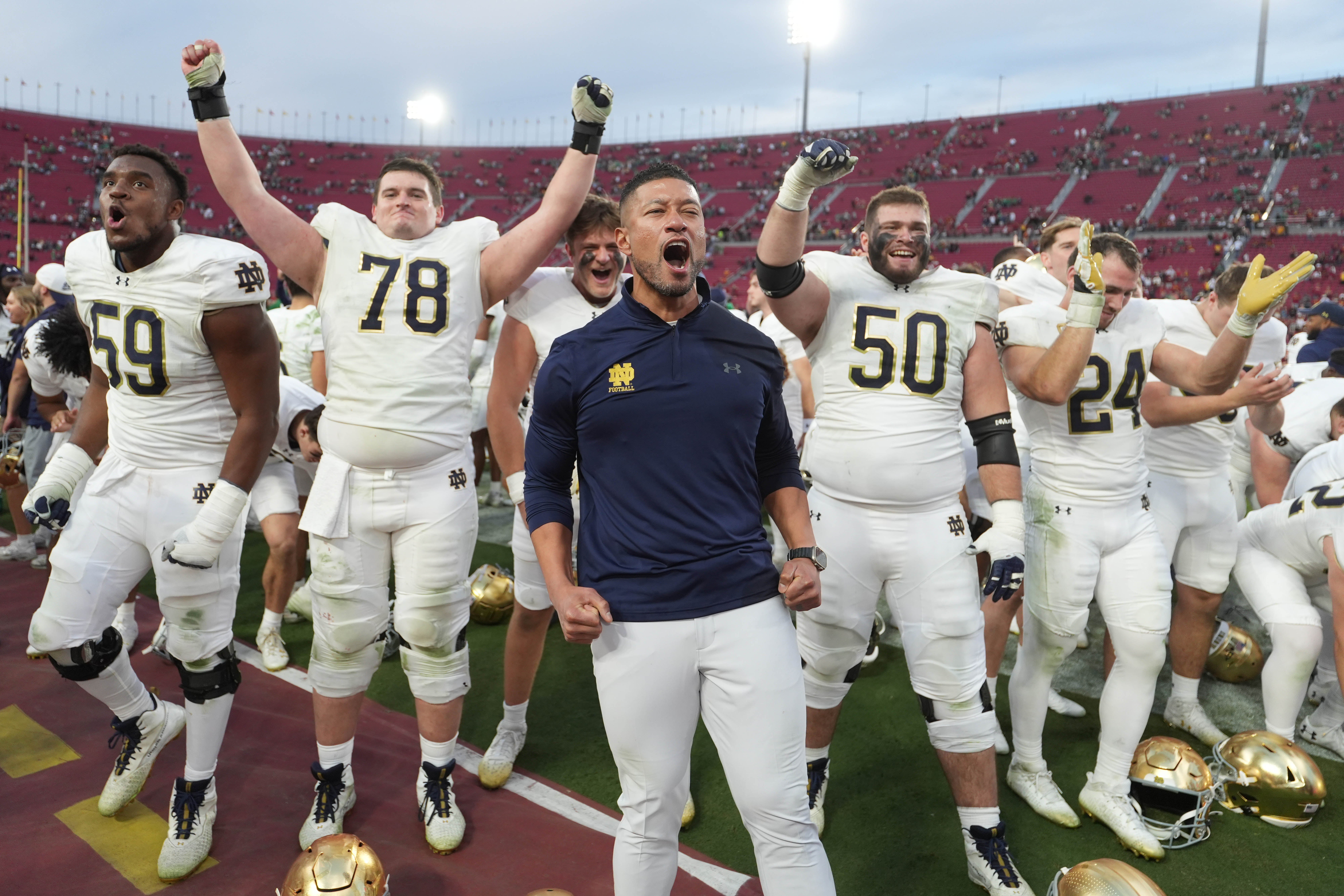 Notre Dame Fighting Irish head coach Marcus Freeman celebrates with players at the end of the game against the Southern California Trojans at United Airlines Field at Los Angeles Memorial Coliseum.
