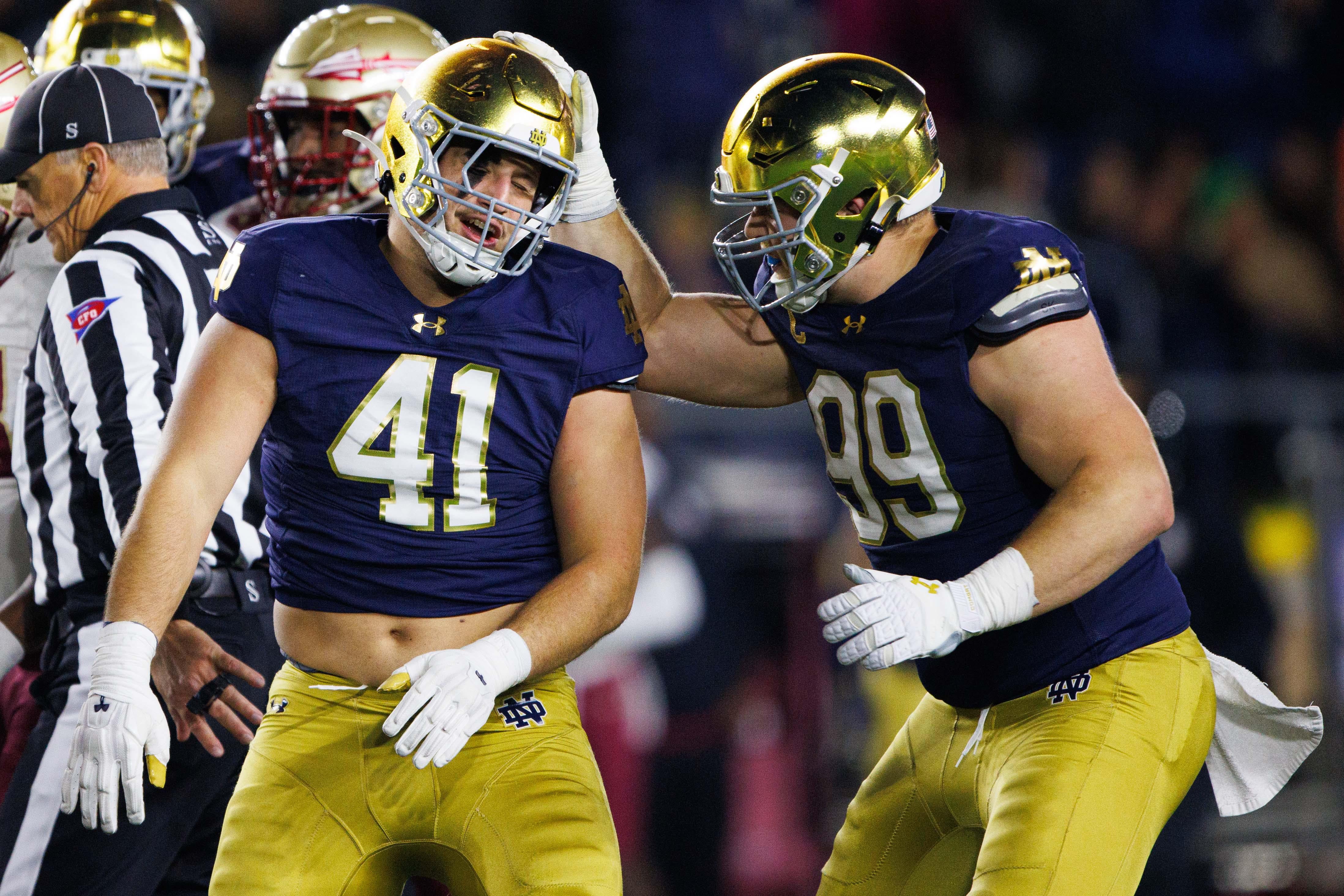 Notre Dame defensive lineman Rylie Mills (99) and defensive lineman Donovan Hinish (41) celebrate getting a stop during a NCAA college football game against Florida State at Notre Dame Stadium on Saturday, Nov. 9, 2024, in South Bend.
