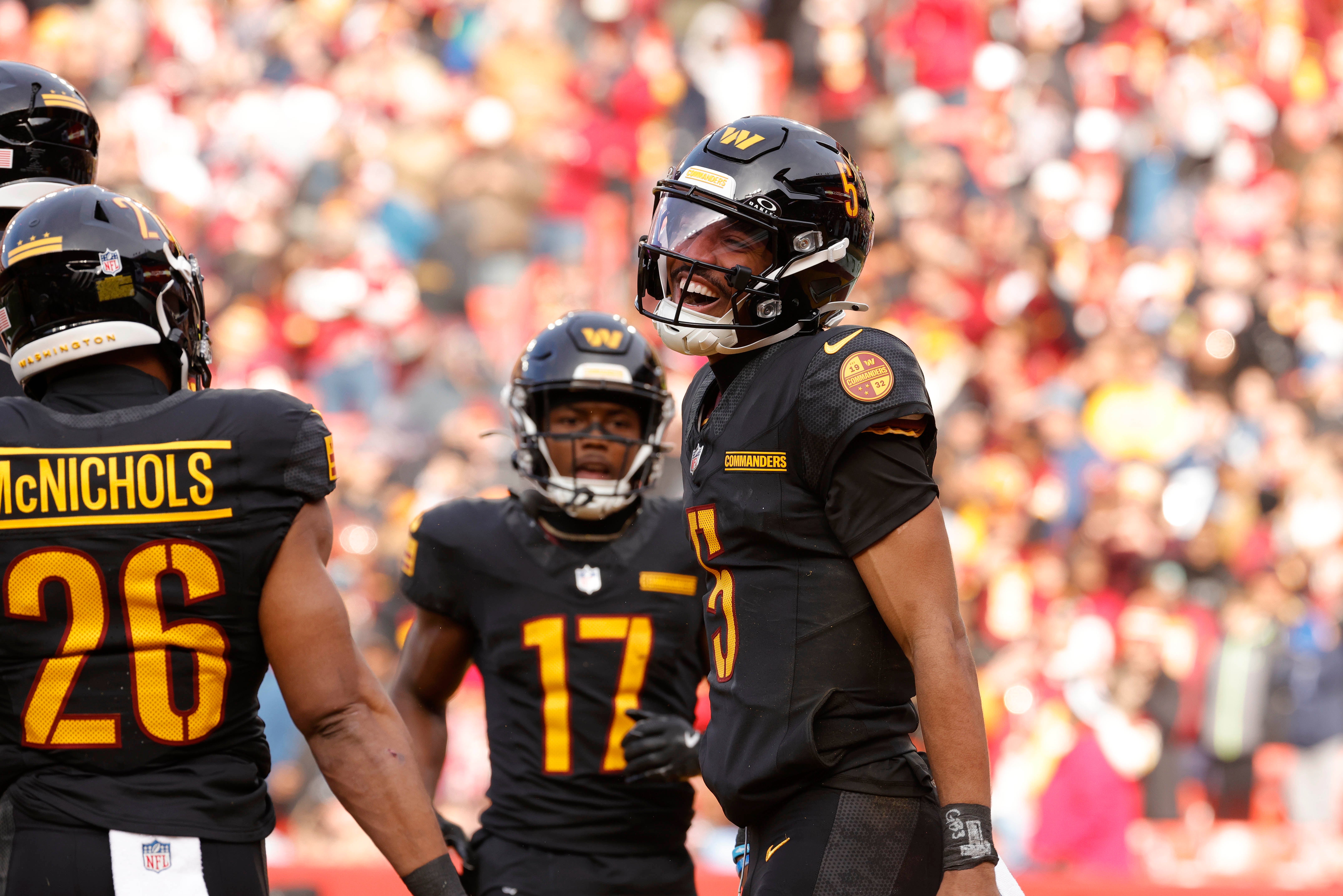 Dec 1, 2024; Landover, Maryland, USA; Washington Commanders quarterback Jayden Daniels (5) celebrates after scoring a touchdown against the Tennessee Titans during the first half at Northwest Stadium.