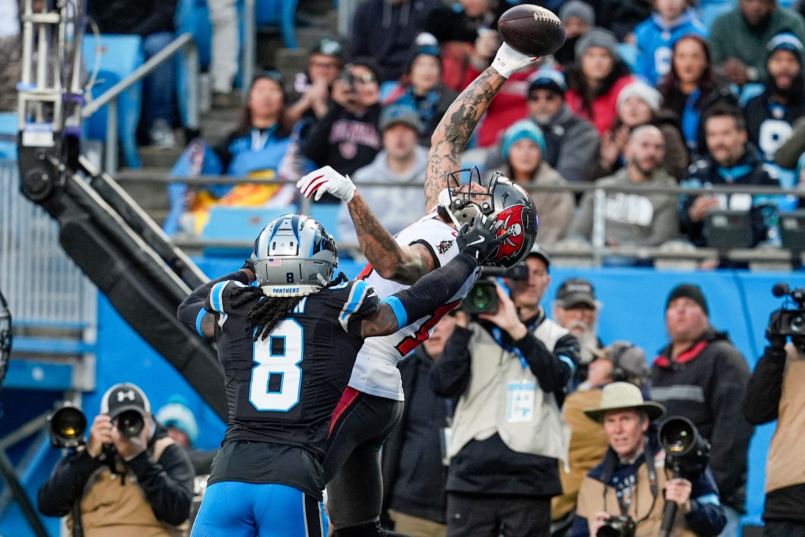 Dec 1, 2024; Charlotte, North Carolina, USA; Tampa Bay Buccaneers wide receiver Mike Evans (13) reaches for the touchdown catch defended by Carolina Panthers cornerback Jaycee Horn (8) during the first quarter at Bank of America Stadium.