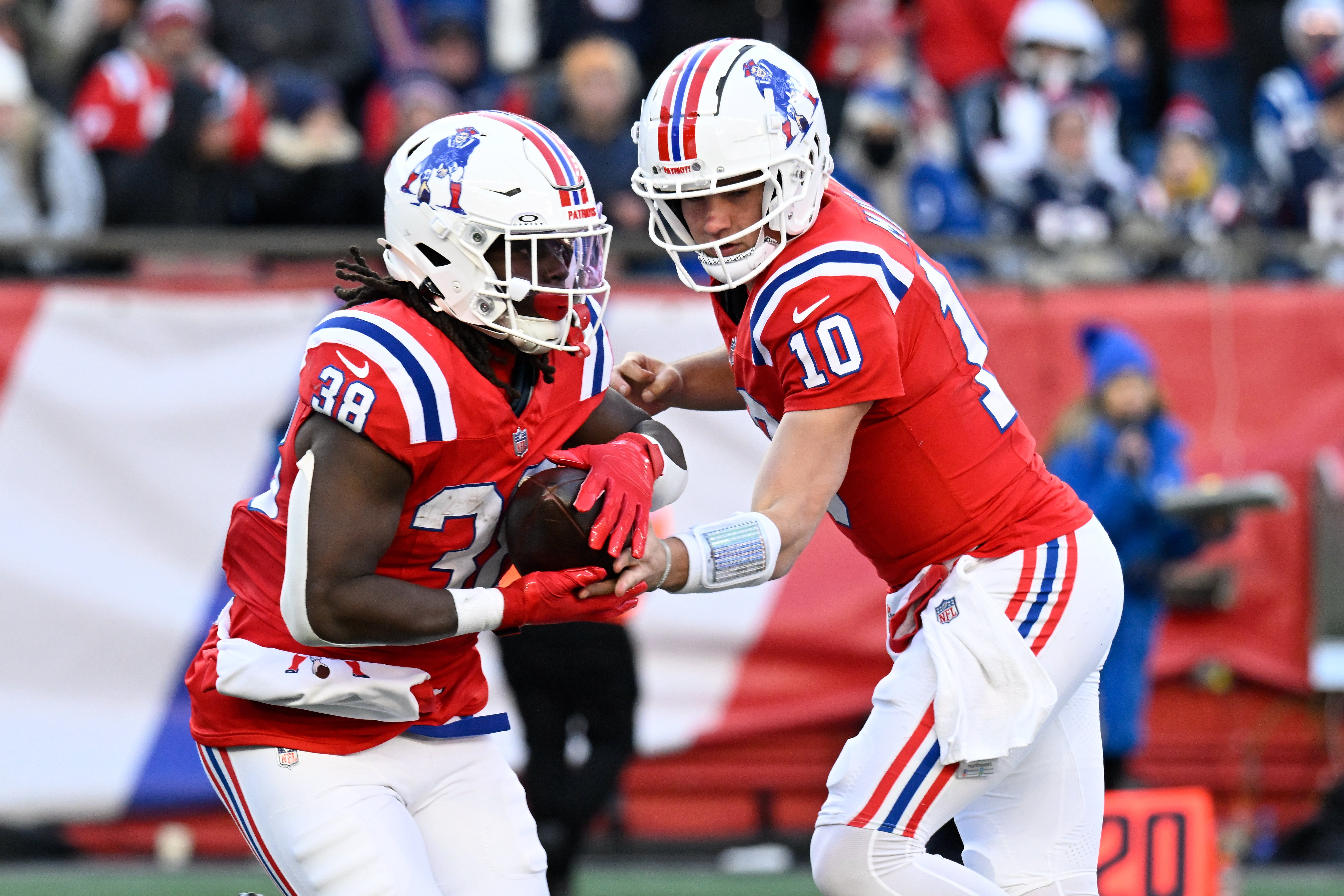 Dec 1, 2024; Foxborough, Massachusetts, USA; New England Patriots quarterback Drake Maye (10) hands the ball to running back Rhamondre Stevenson (38) during the second half at Gillette Stadium.