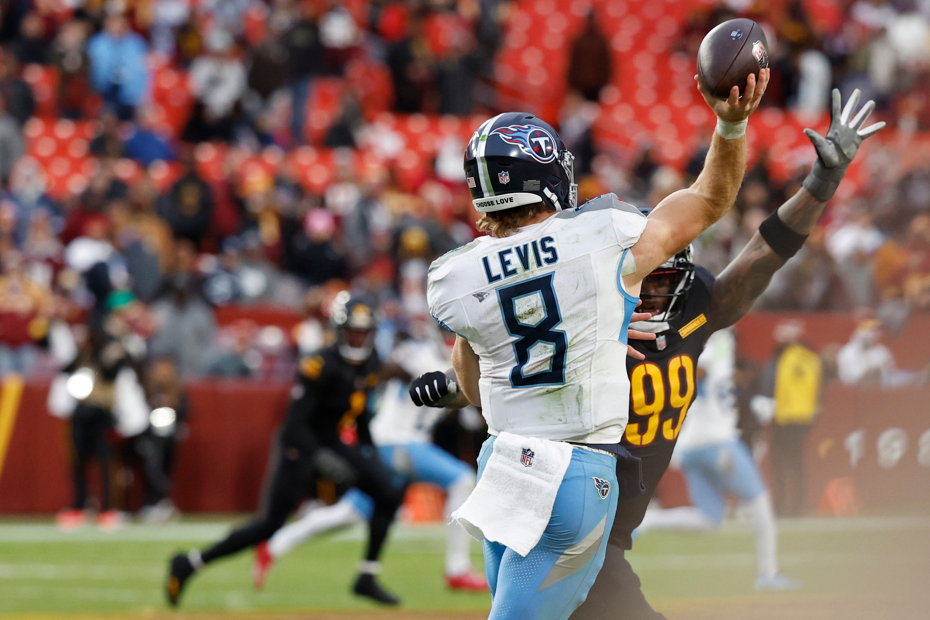 Dec 1, 2024; Landover, Maryland, USA; Tennessee Titans quarterback Will Levis (8) passes the ball under pressure from Washington Commanders defensive end Clelin Ferrell (99) during the fourth quarter at Northwest Stadium. Mandatory Credit: Geoff Burke-Imagn Images