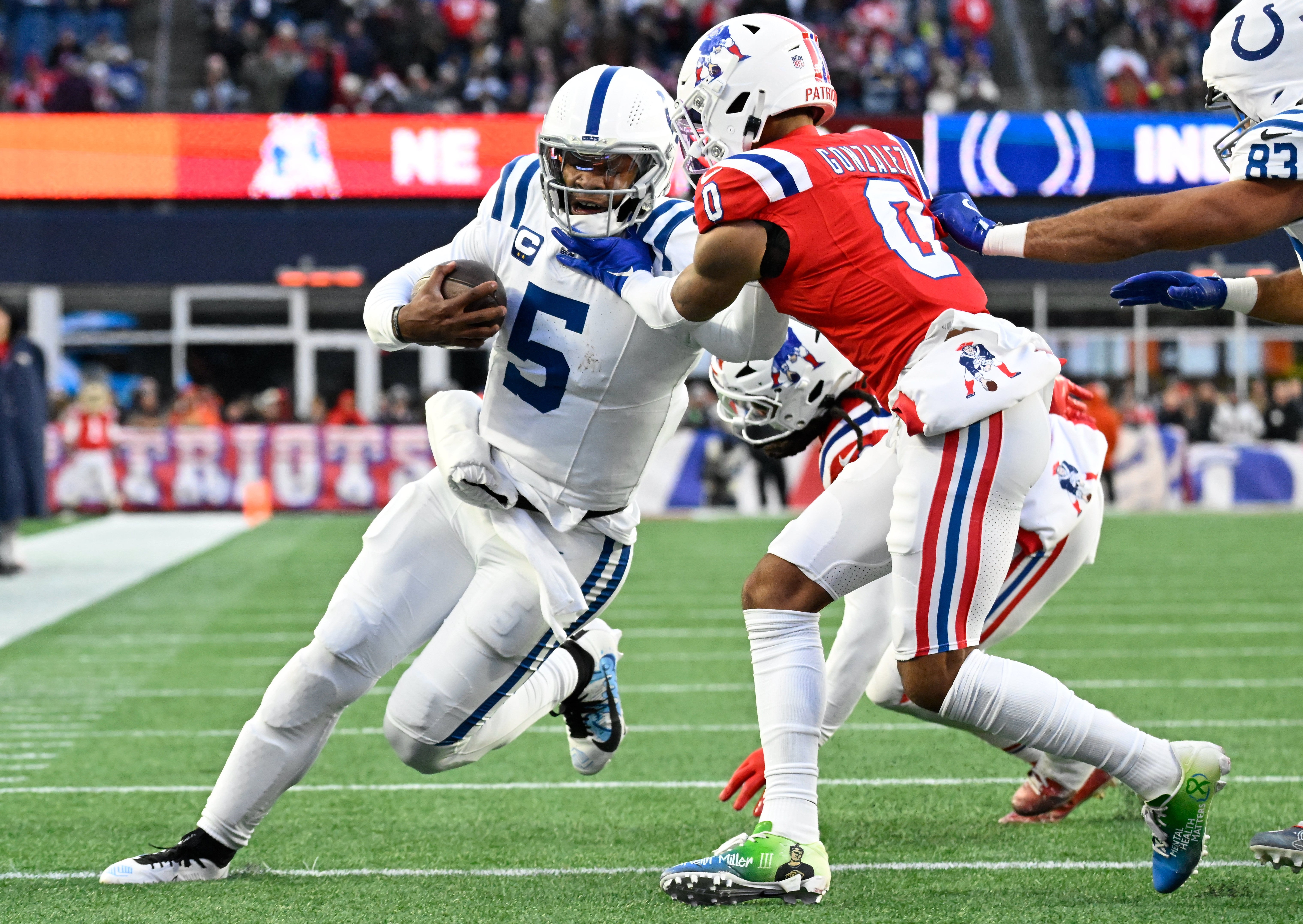 Dec 1, 2024; Foxborough, Massachusetts, USA; New England Patriots cornerback Christian Gonzalez (0) tackles Indianapolis Colts quarterback Anthony Richardson (5) during the second half at Gillette Stadium.