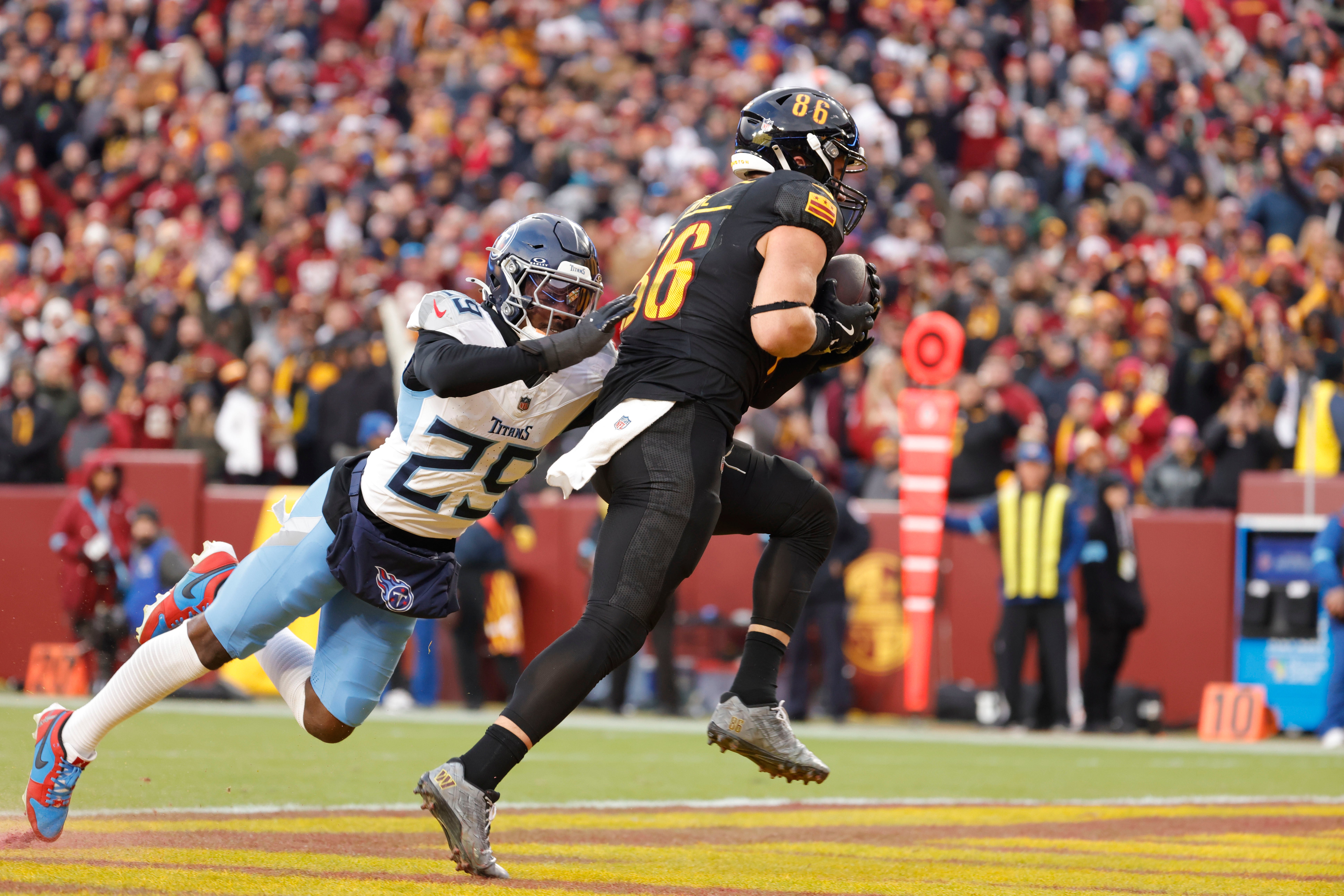 Washington Commanders tight end Zach Ertz (86) scores a touchdown past Tennessee Titans cornerback Jarvis Brownlee Jr. (29) during the second half at Northwest Stadium. Amber Searls-Imagn Images