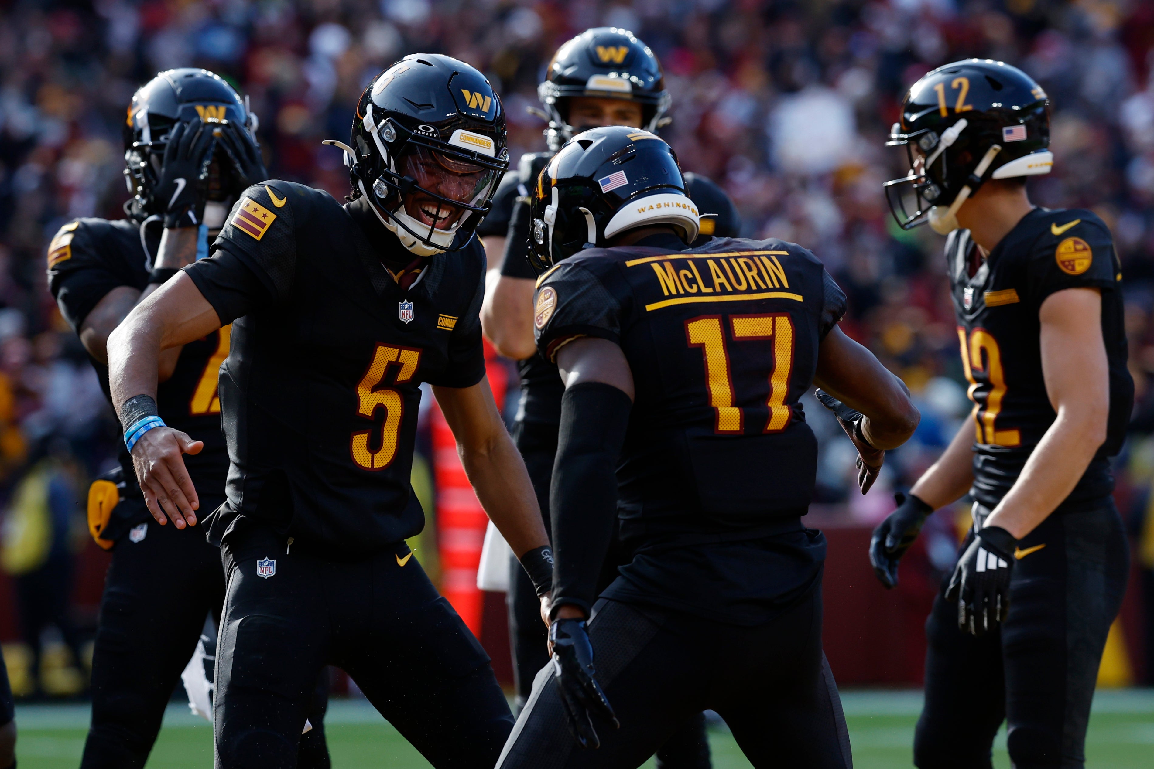 Dec 1, 2024; Landover, Maryland, USA; Washington Commanders wide receiver Terry McLaurin (17) and Commanders quarterback Jayden Daniels (5) celebrate after connecting on a touchdown pass against the Tennessee Titans during the first quarter at Northwest Stadium.