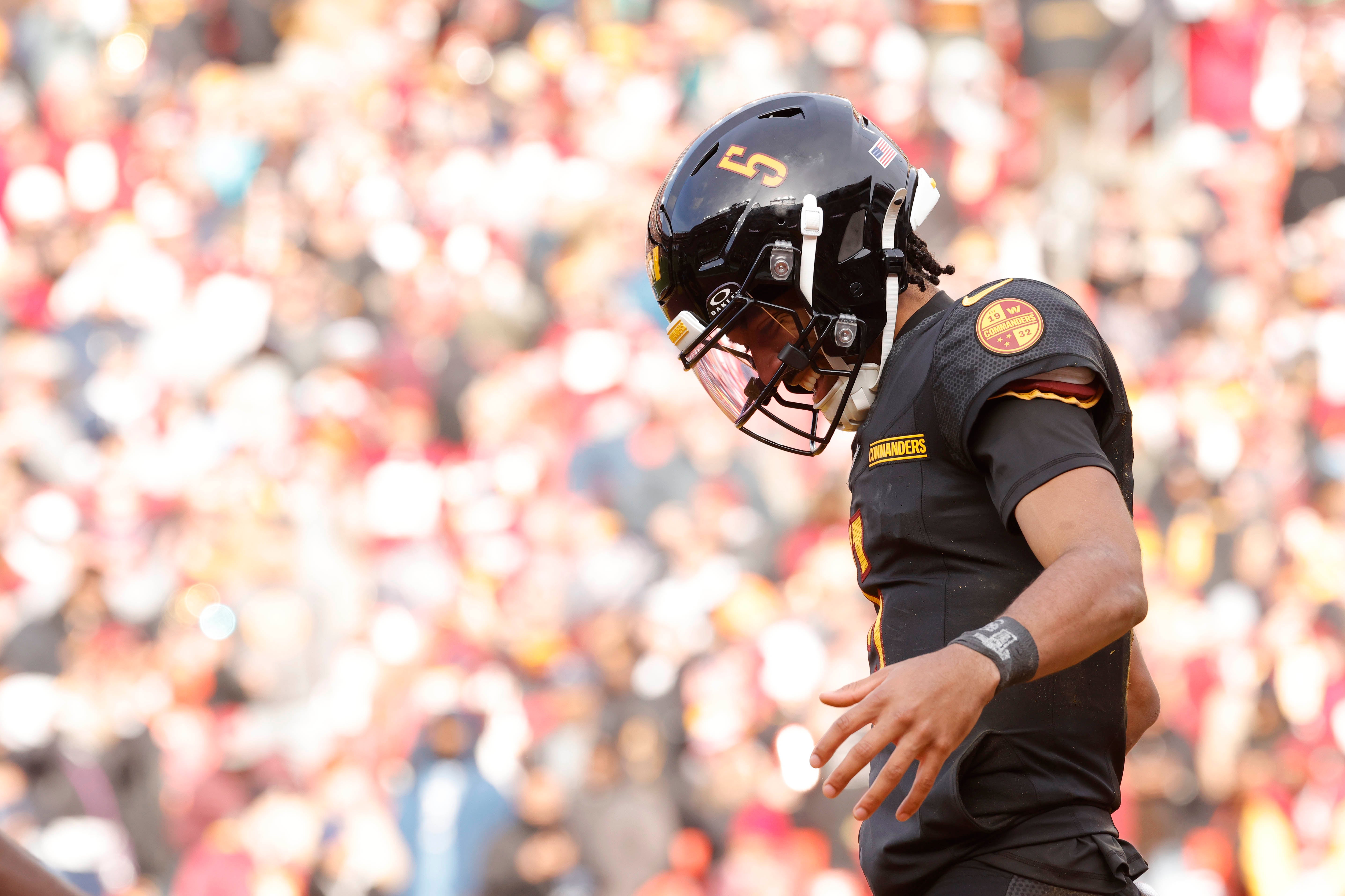 Dec 1, 2024; Landover, Maryland, USA; Washington Commanders quarterback Jayden Daniels (5) celebrates after scoring a touchdown against the Tennessee Titans during the first half at Northwest Stadium.