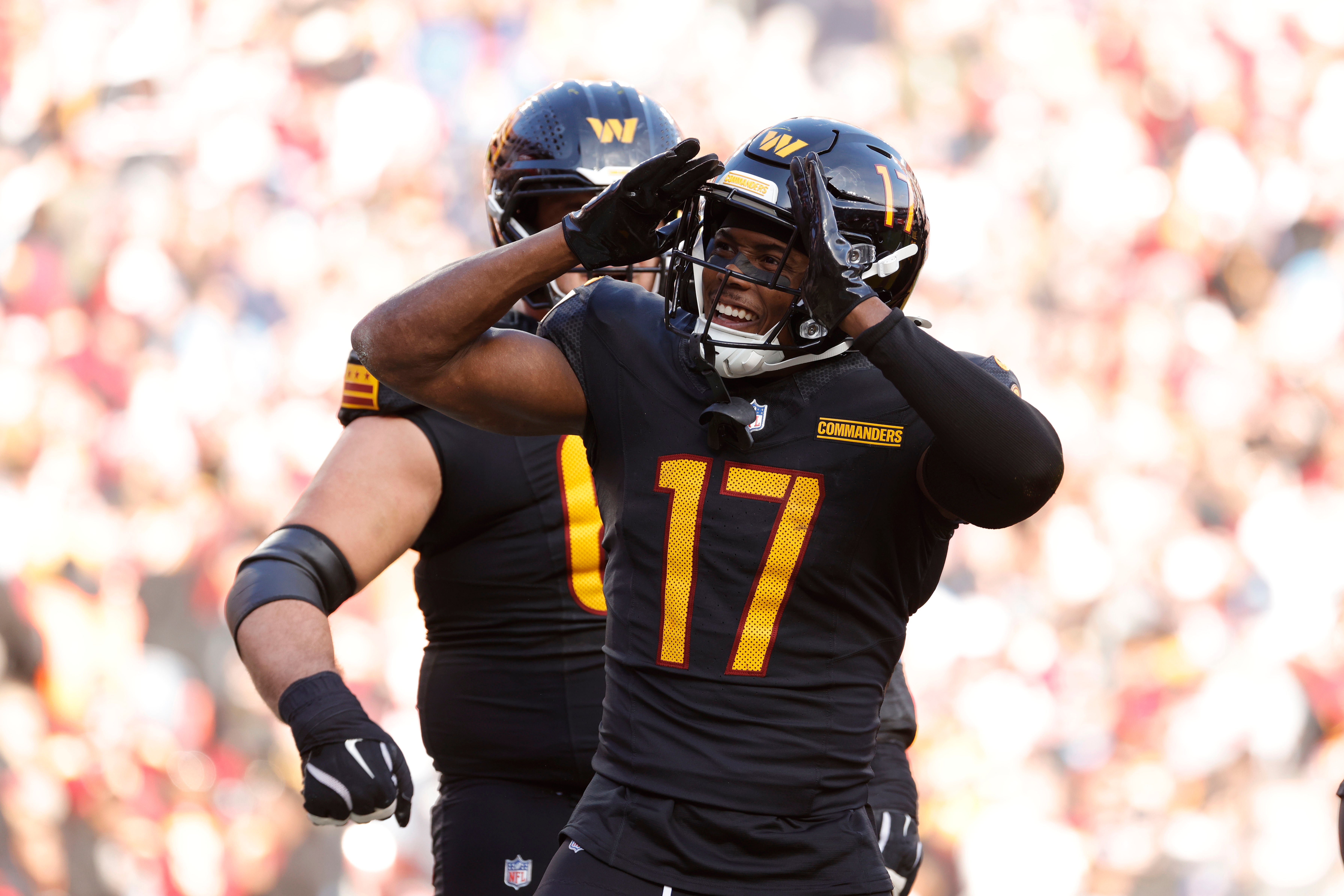 Dec 1, 2024; Landover, Maryland, USA; Washington Commanders wide receiver Terry McLaurin (17) celebrates with fans in the stands after scoring a touchdown against Tennessee Titans during the first half at Northwest Stadium.